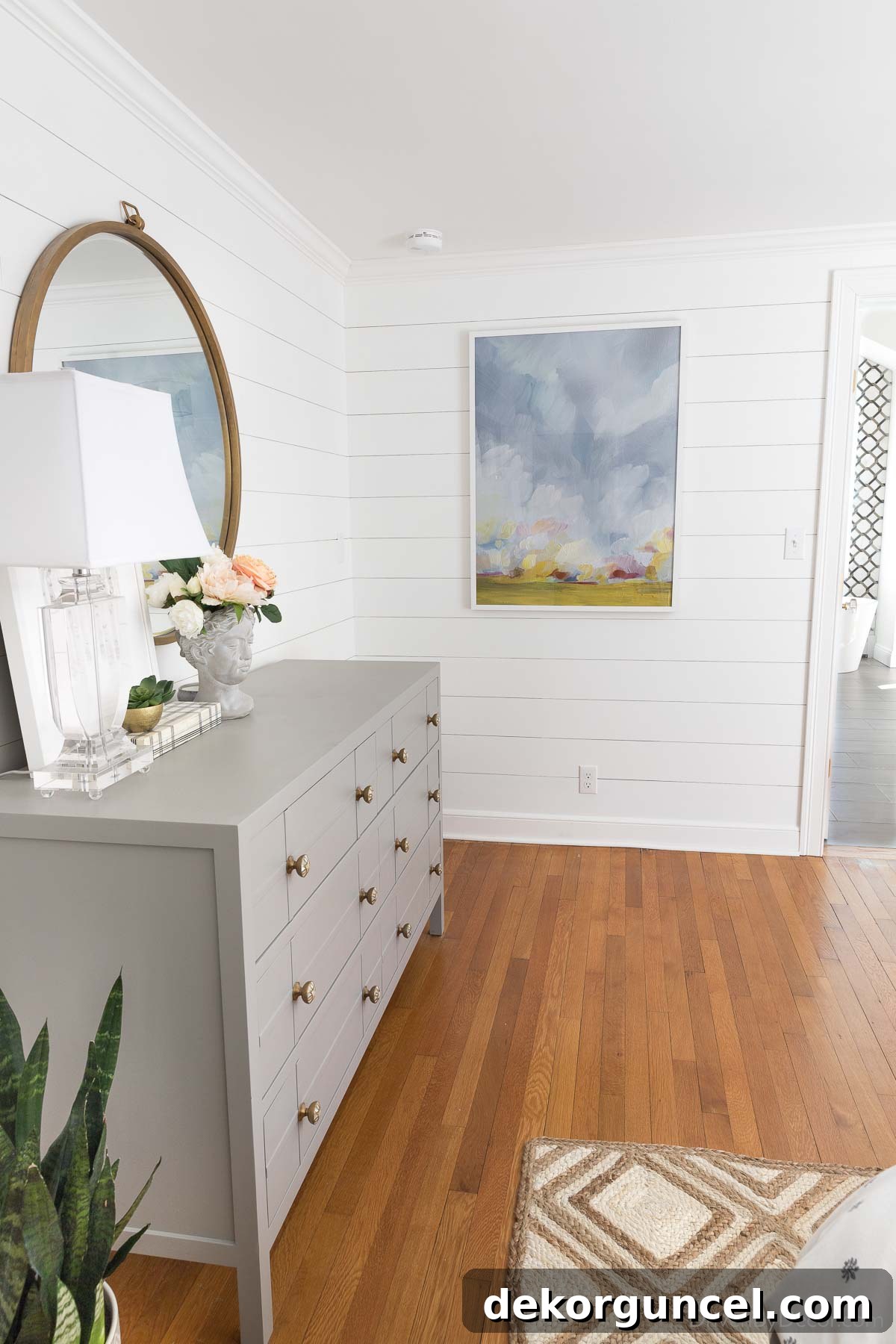 Bedroom with large picture hung on shiplap wall - shows how high to hang a single picture