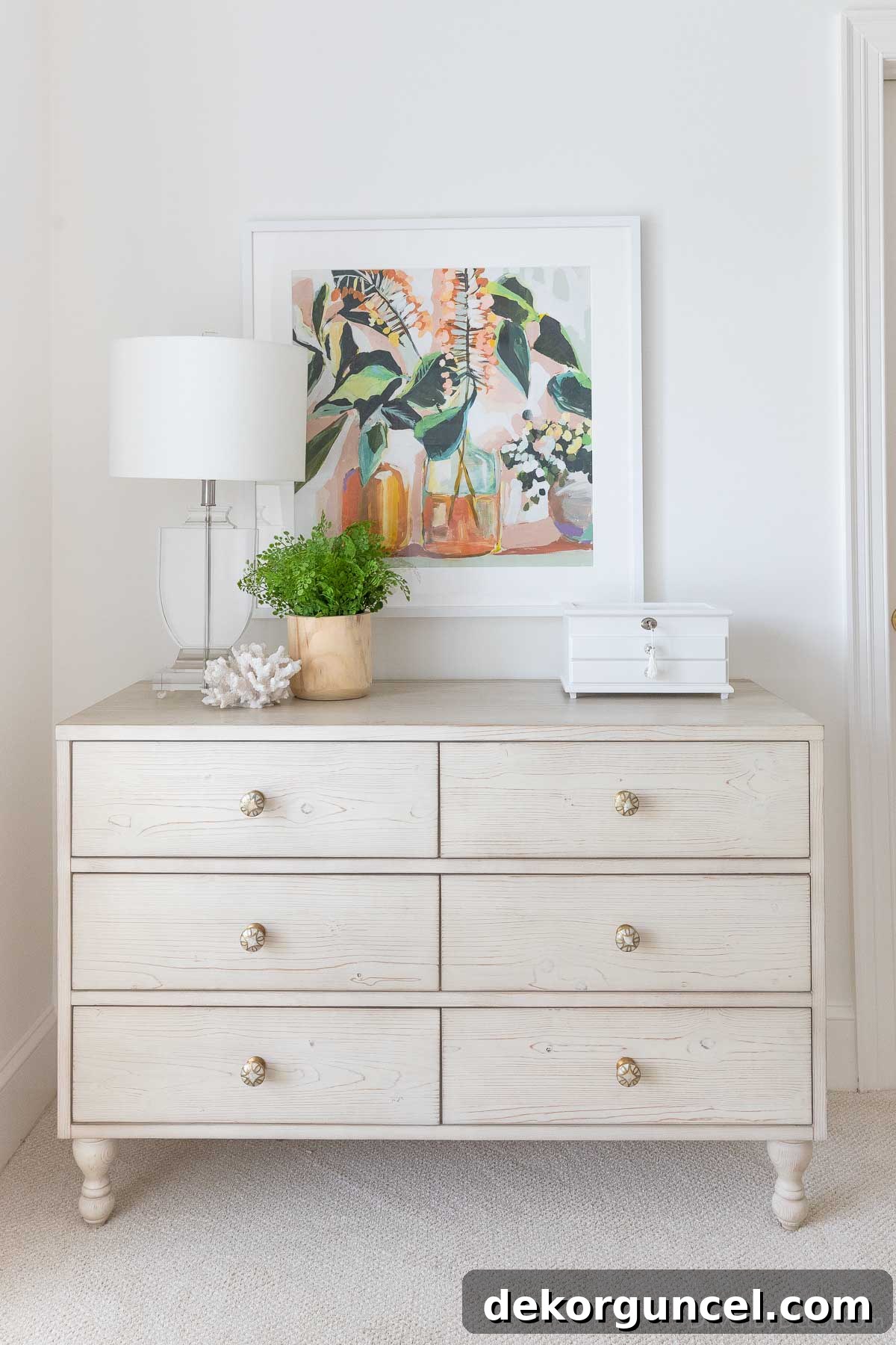 Floral picture hung over dresser to show how high you should hang art over furniture