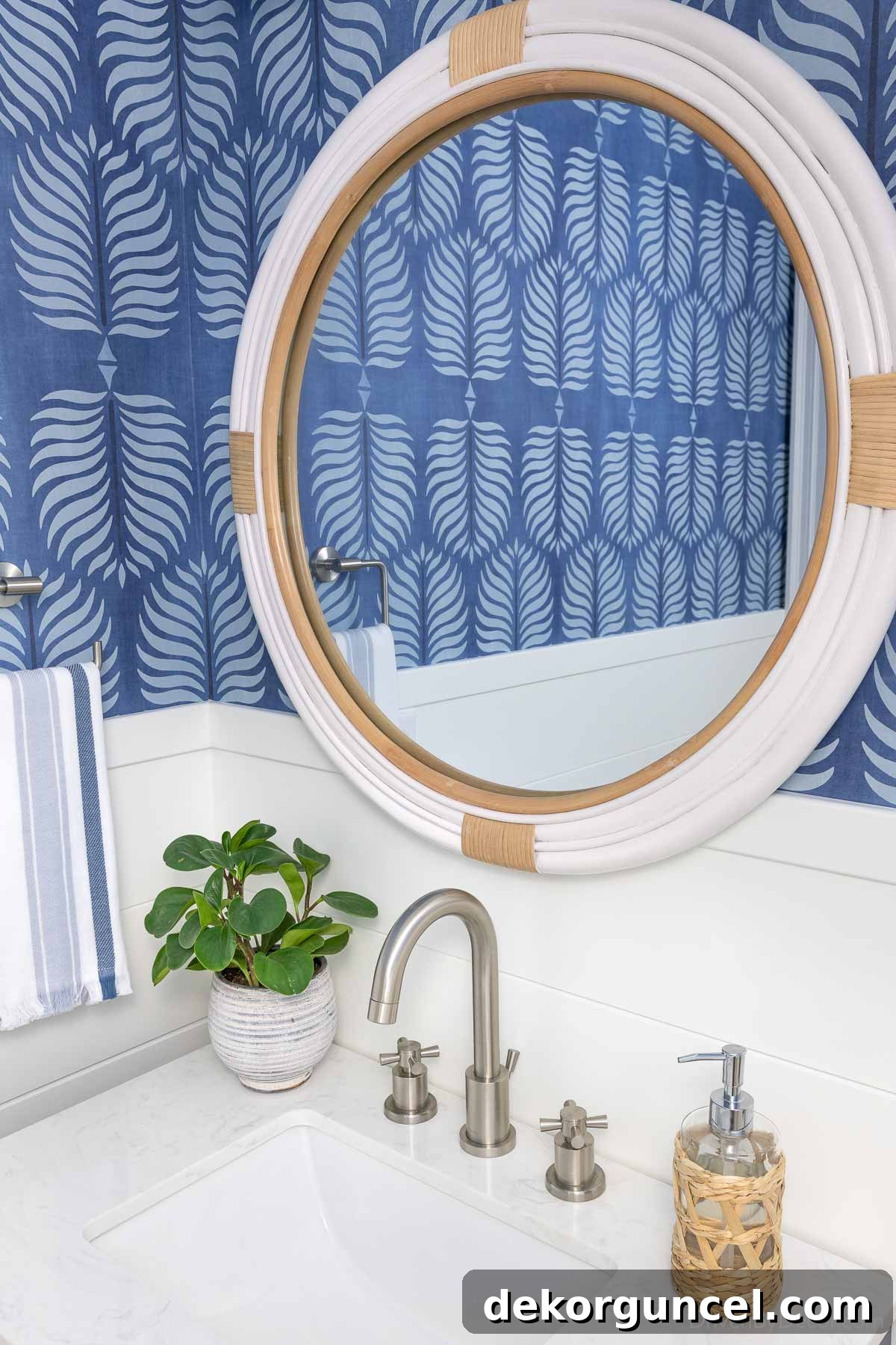Round white rattan mirror above sink in powder room, tying in coastal elements