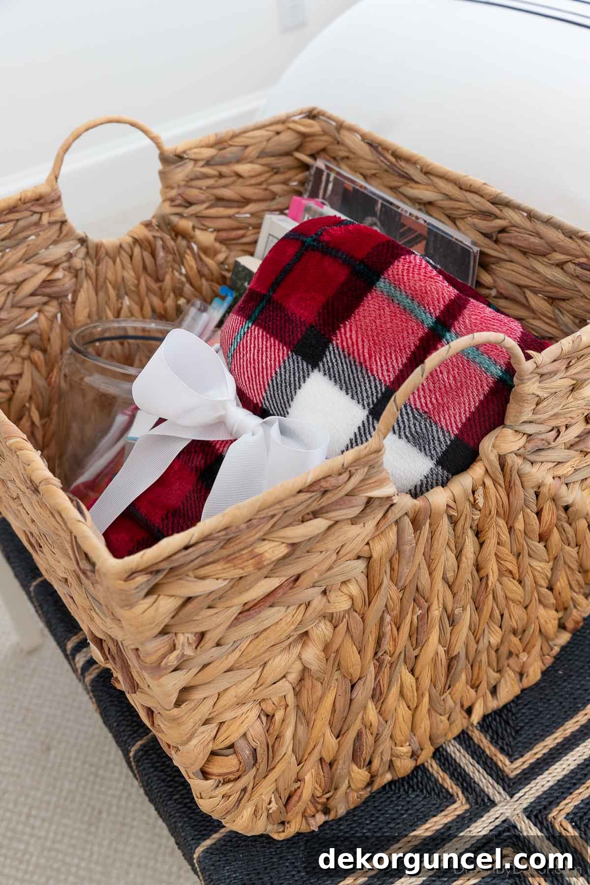 Cozy red plaid throw blanket neatly rolled up in a welcome basket for guests