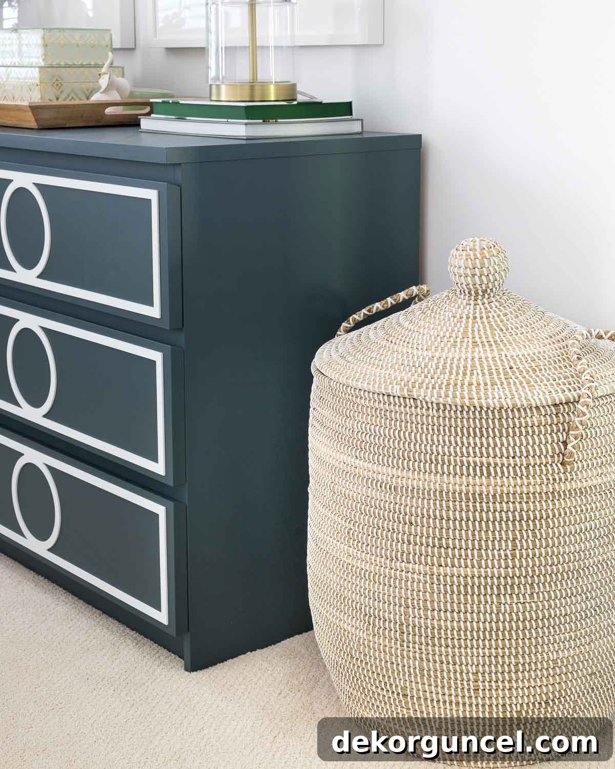 Elegant lidded basket serving as a hamper, placed beside a dresser in a bedroom