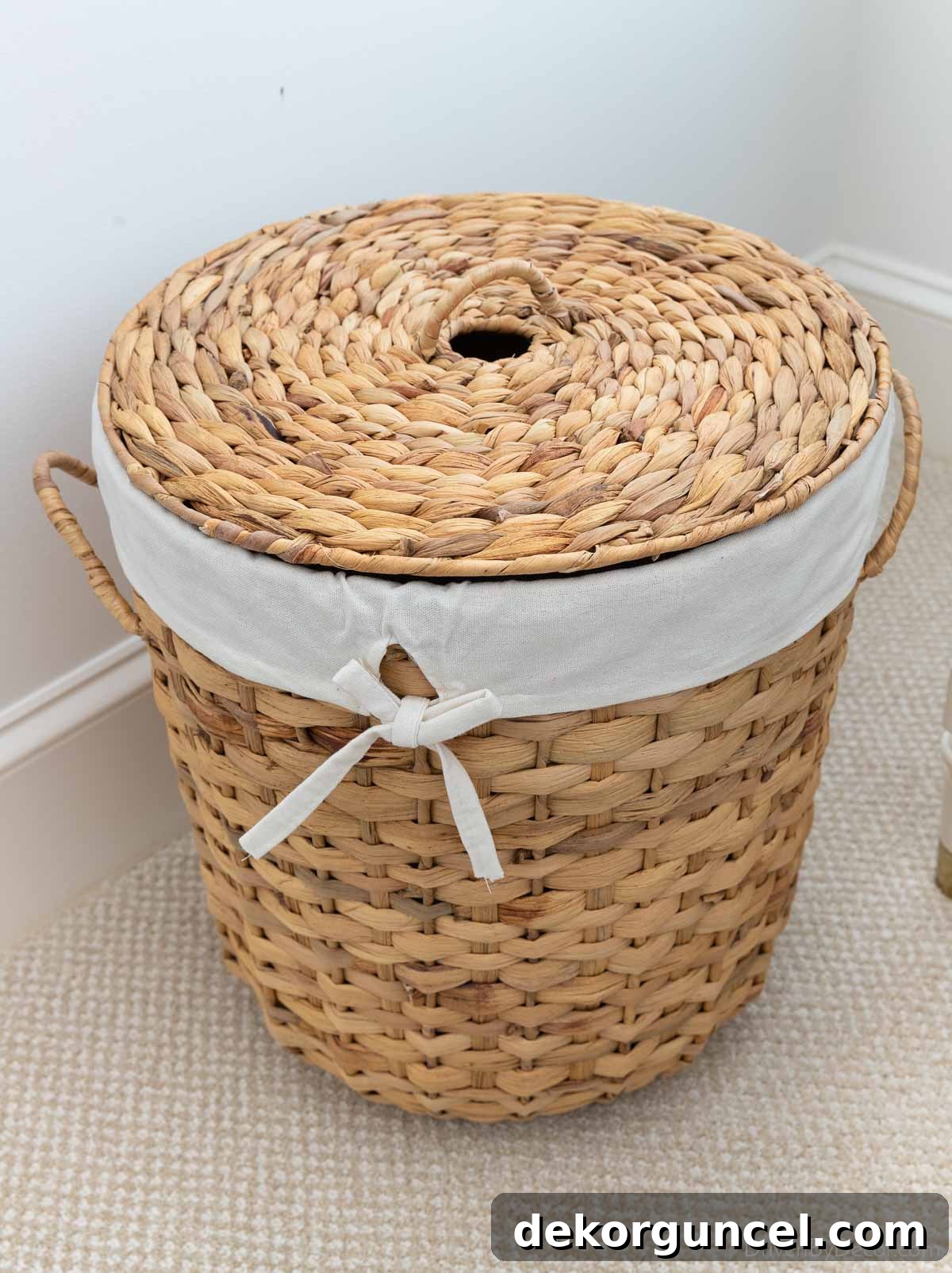 Stylish woven basket repurposed as a hamper in a guest bedroom