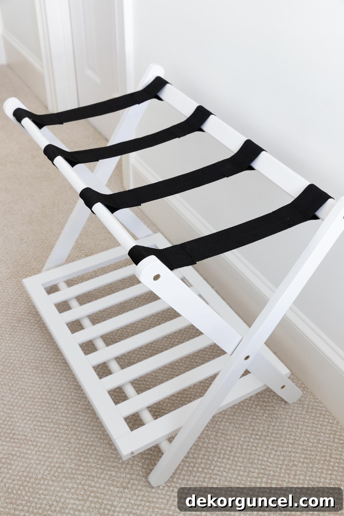 Elegant white luggage rack, perfect for a modern guest bedroom