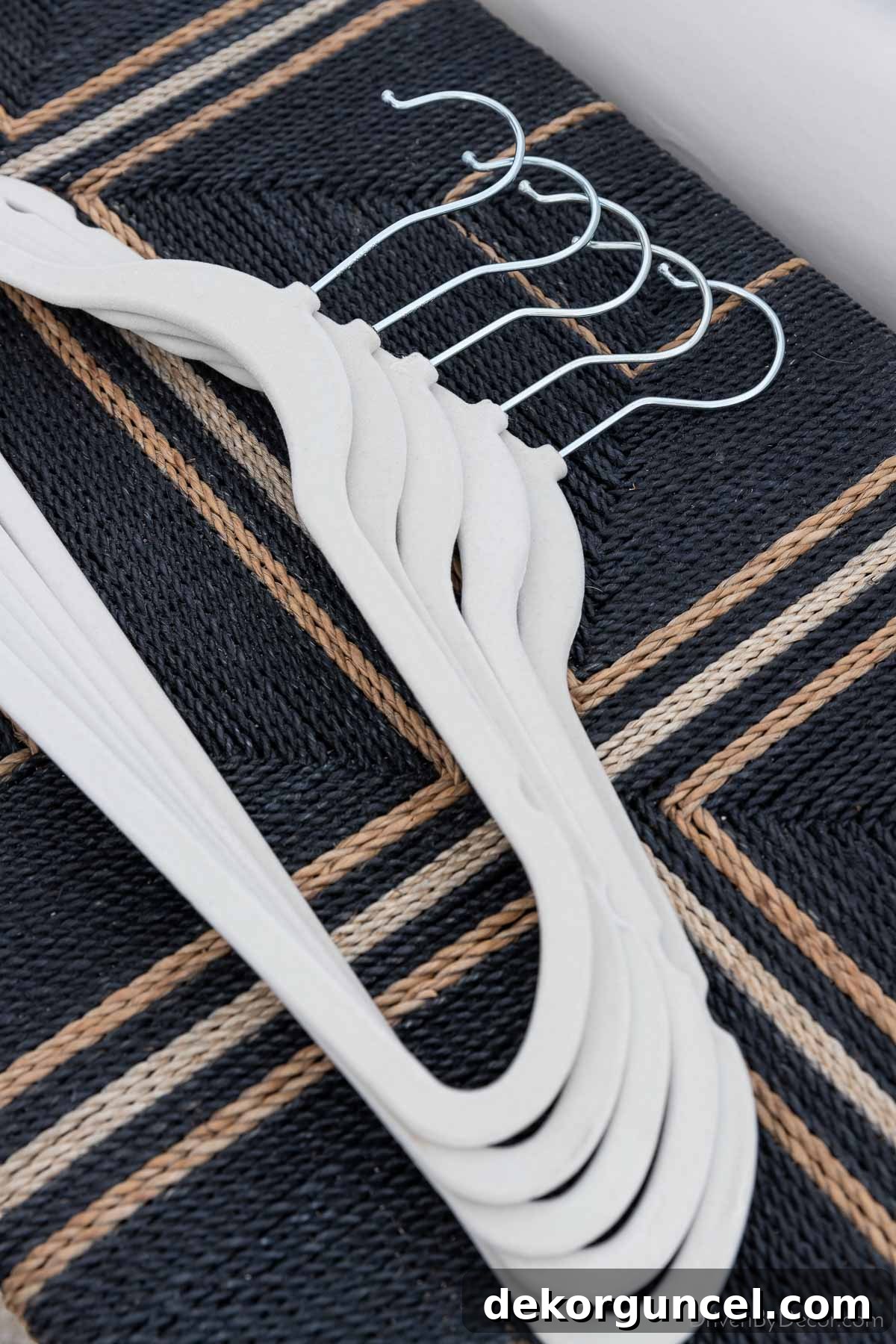 Stack of slim white velvet hangers, ideal for maximizing closet space