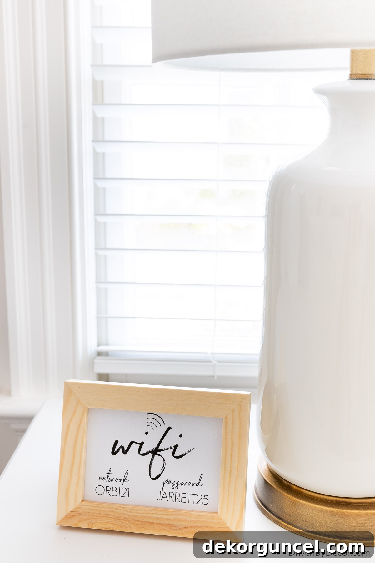 Framed Wi-Fi network and password displayed on a guest bedroom nightstand