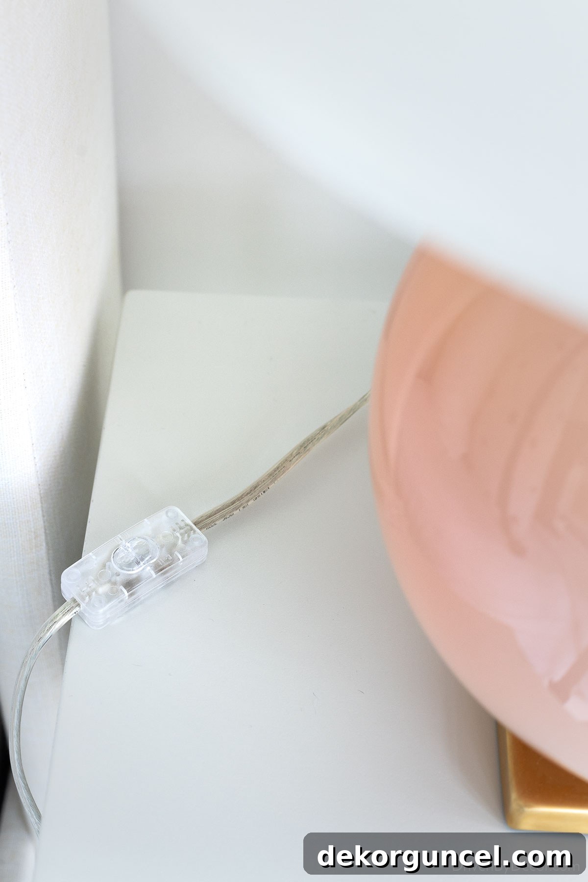 Close-up of an in-line switch button on a lamp cord, offering a convenient and modern way to control bedroom lighting
