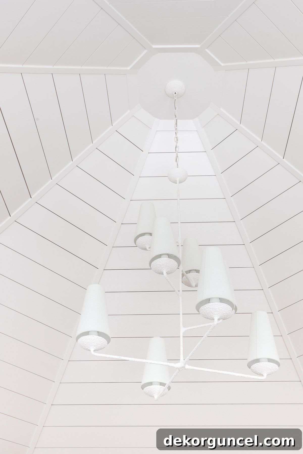 Unveiling 2023 Home Decor Trends 8 Tiered plaster chandelier hung on a shiplap ceiling, showcasing a modern fixture softened by an organic plaster finish