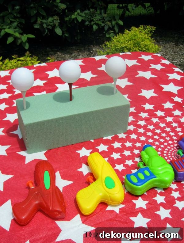 Carnival party water gun game - shoot the ping pong ball off the tees!