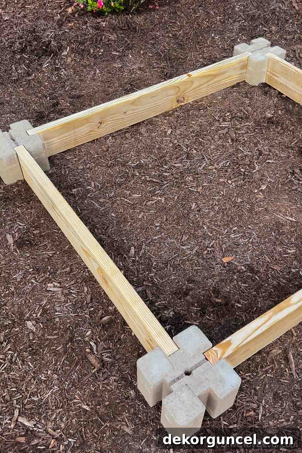 6 Budget-Friendly Raised Garden Bed Ideas 5 Four corner blocks and lumber boards arranged for the base of a raised garden bed