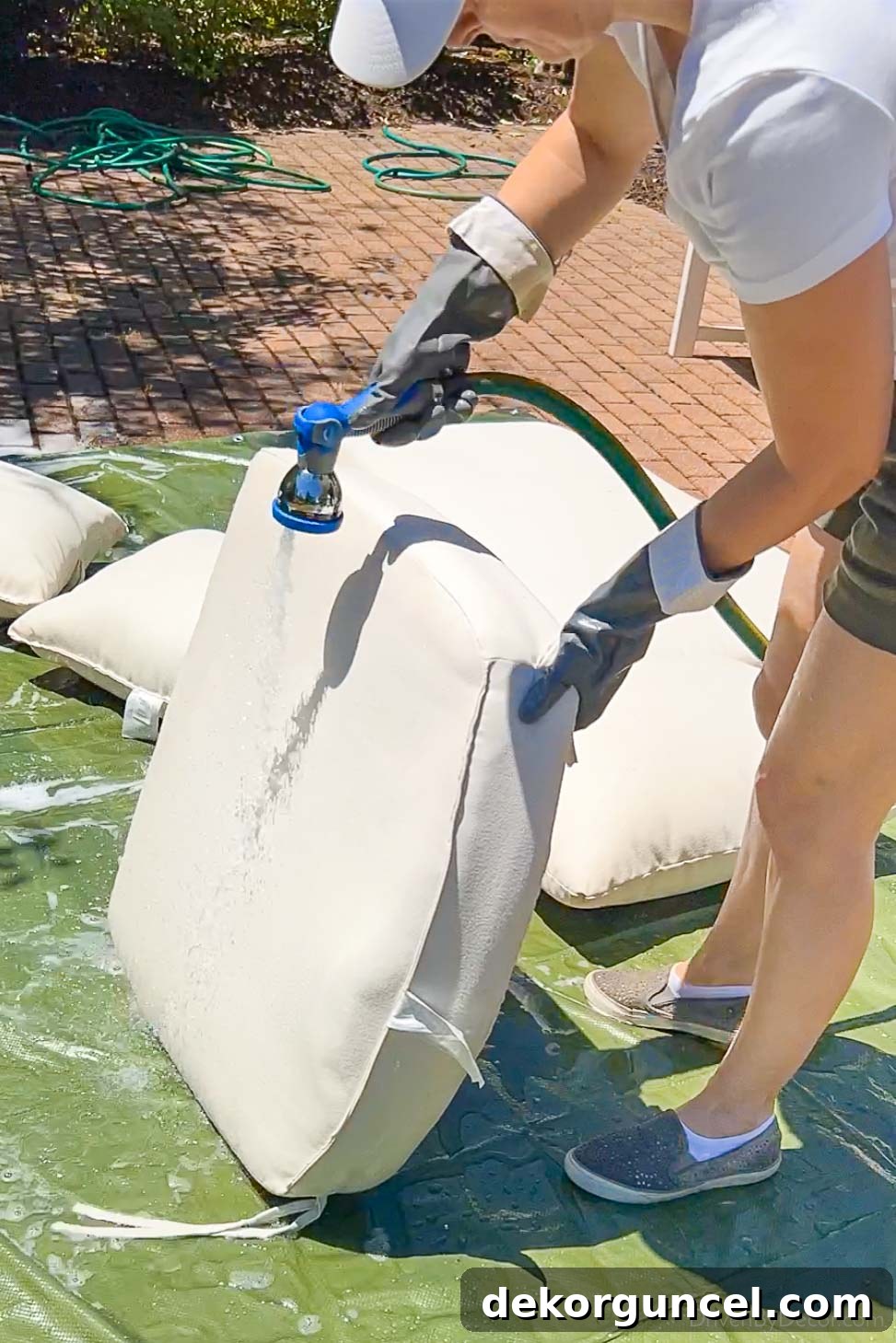Banish Pollen: Essential Tools for a Spotless Porch & Outdoor Furniture 5 Rinsing cushion standing on end to drain dirty water, a crucial step in cleaning outdoor cushions