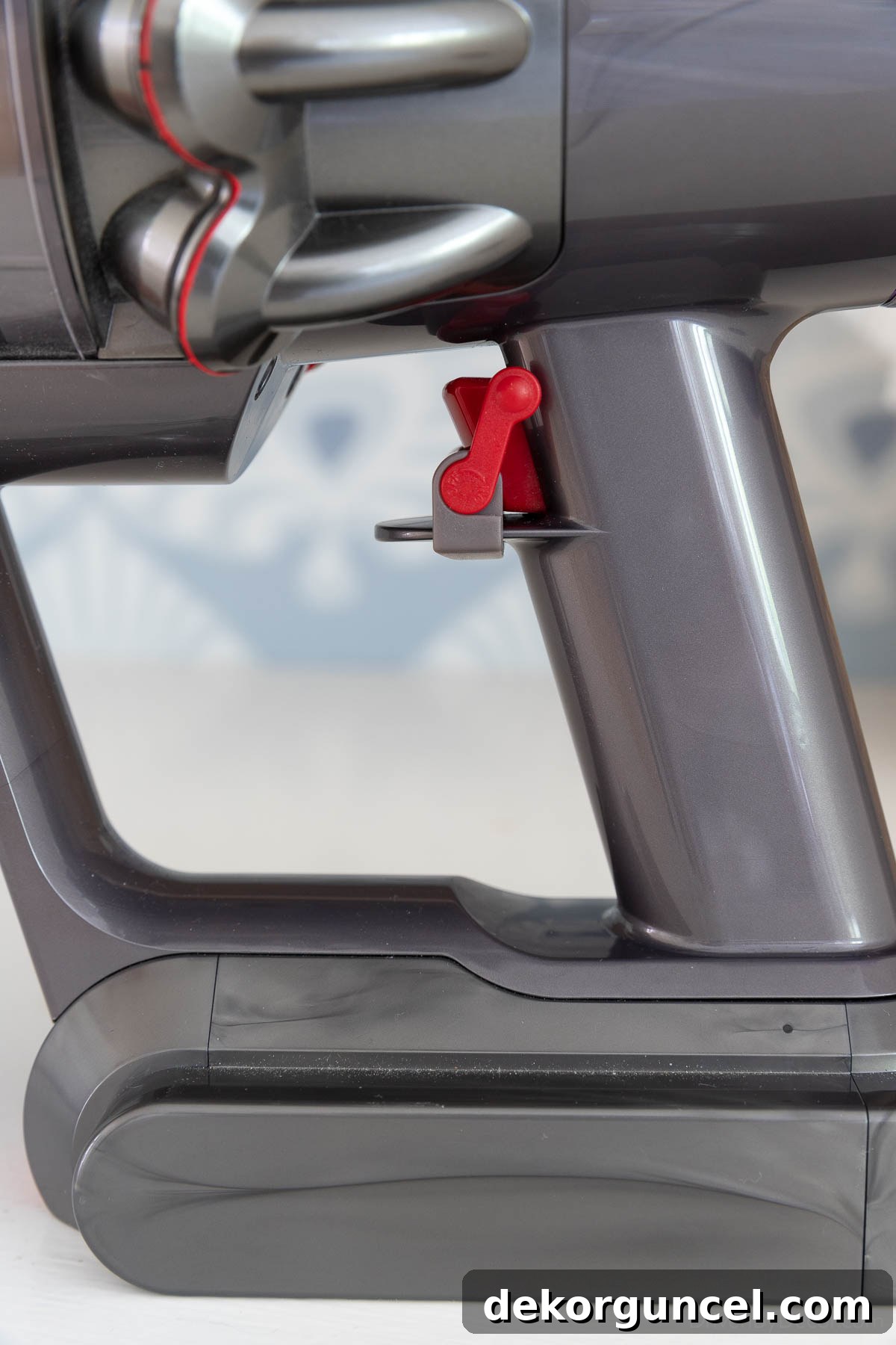Close-up of Dyson trigger with on/off clamp in the 'off' position, red lever pointing up