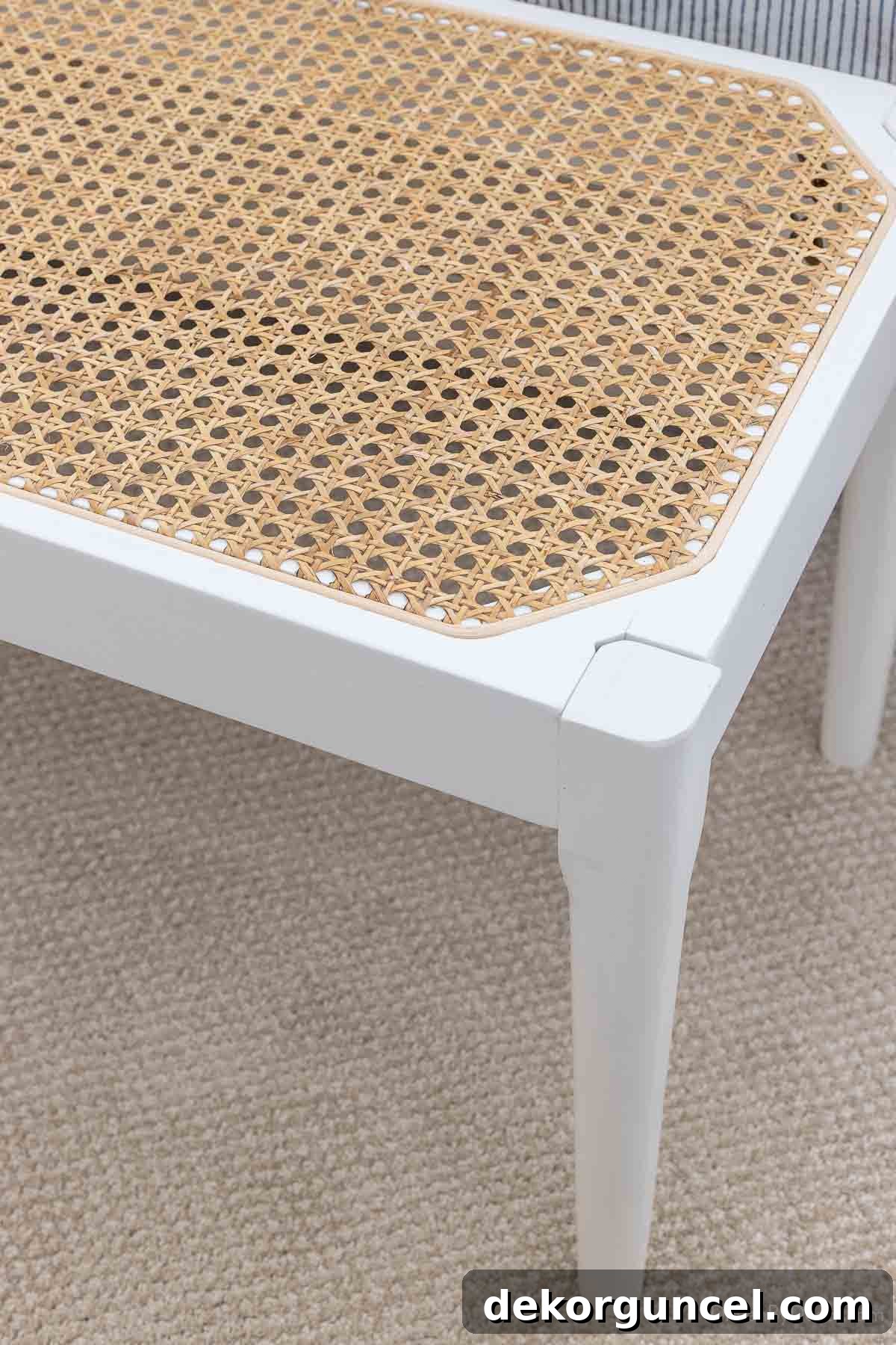 Close-up of intricate cane detailing on an end-of-bed bench, highlighting the natural material's texture in a coastal bedroom setting
