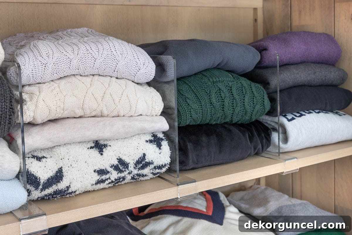 Acrylic shelf dividers maintaining neatly stacked sweaters in a cabinet