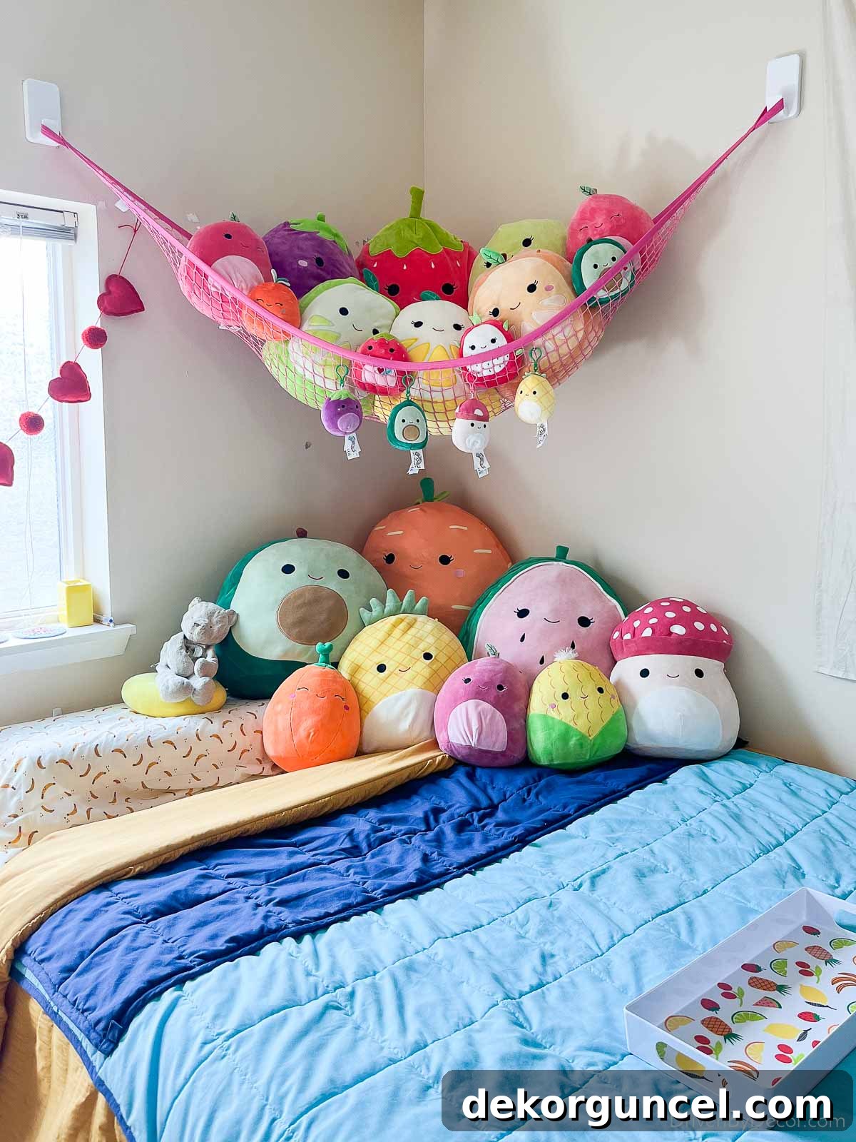 Squishmallows on bed and in a wall hammock, showing stuffed animal organization
