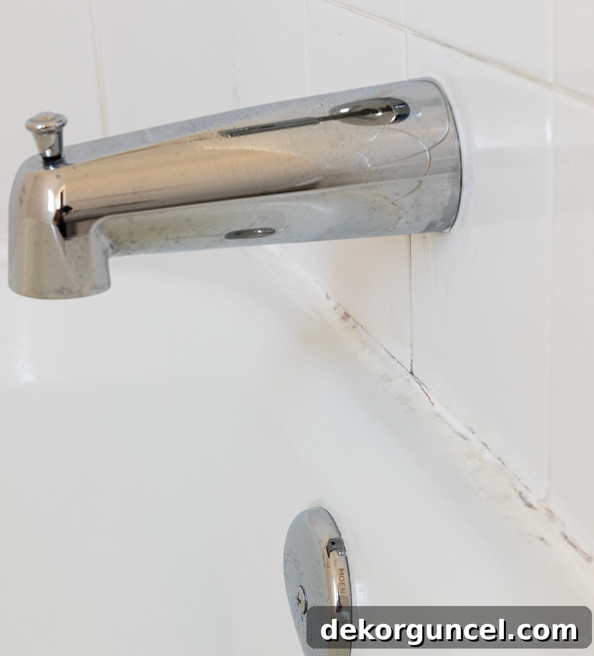 Old cracked caulk around bathtub needing replacement