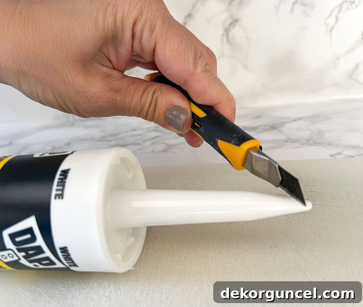 Cutting off tip of caulk tube at a 45-degree angle