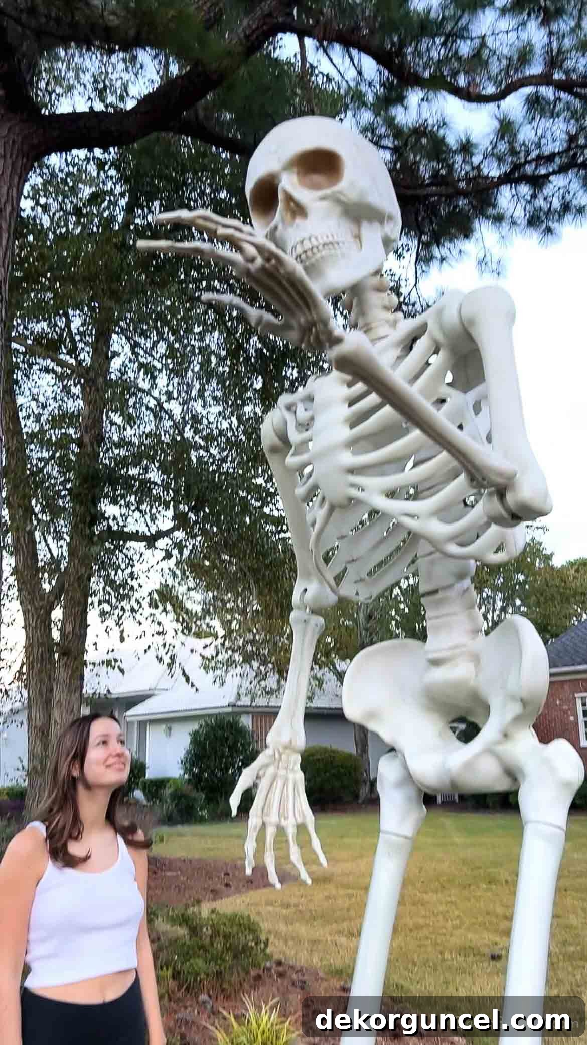 Simple, Spooky, and Fun Halloween Porch Decor Ideas 5 Giant skeleton in front yard next to person showing how tall it is