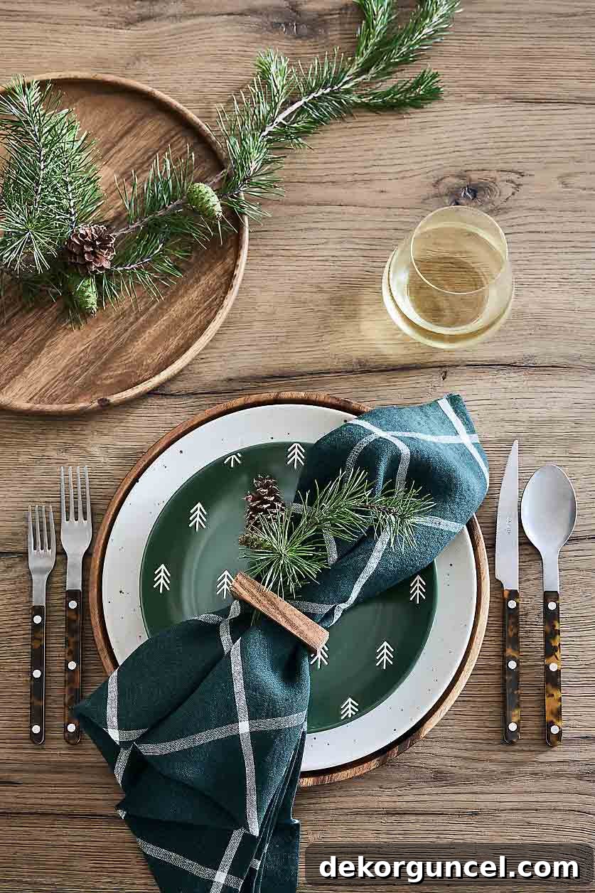 Christmas table decor with greenery tucked in napkin rings