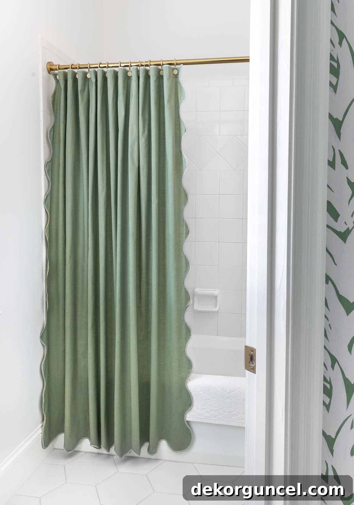 Scalloped green shower curtain with a brass rod in the newly renovated tub/shower and toilet room