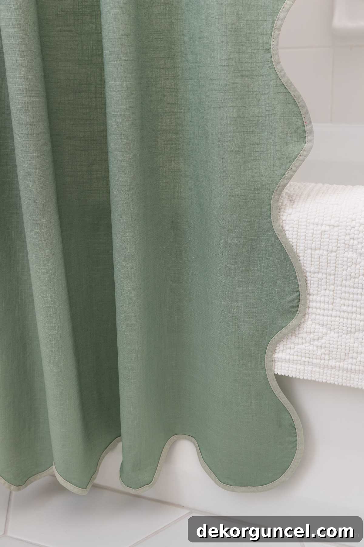 Elegant scalloped green shower curtain hanging from a gold shower rod, adding a pop of color
