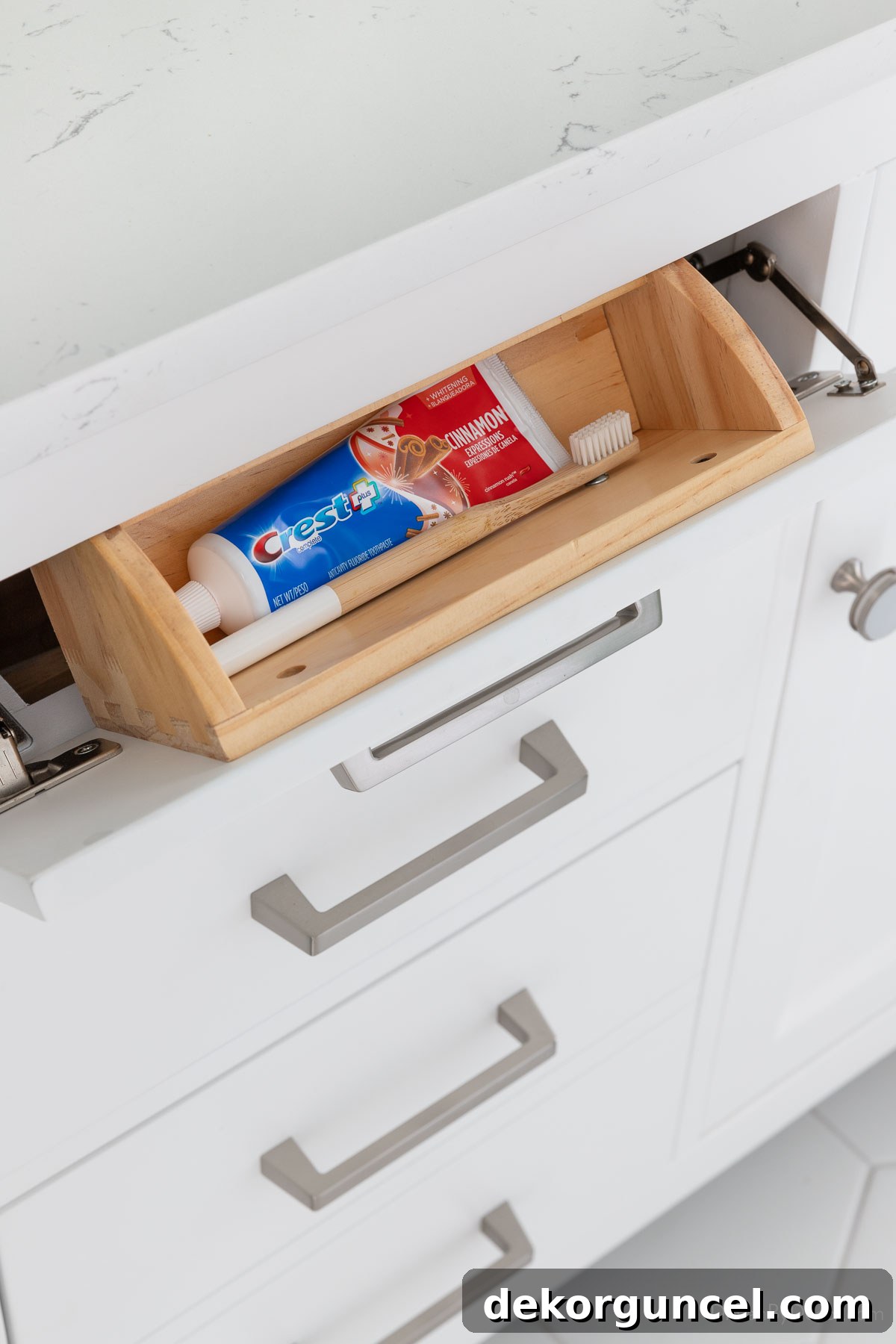 Tilt out tray in bathroom vanity, neatly holding toothbrush and toothpaste for a clutter-free counter