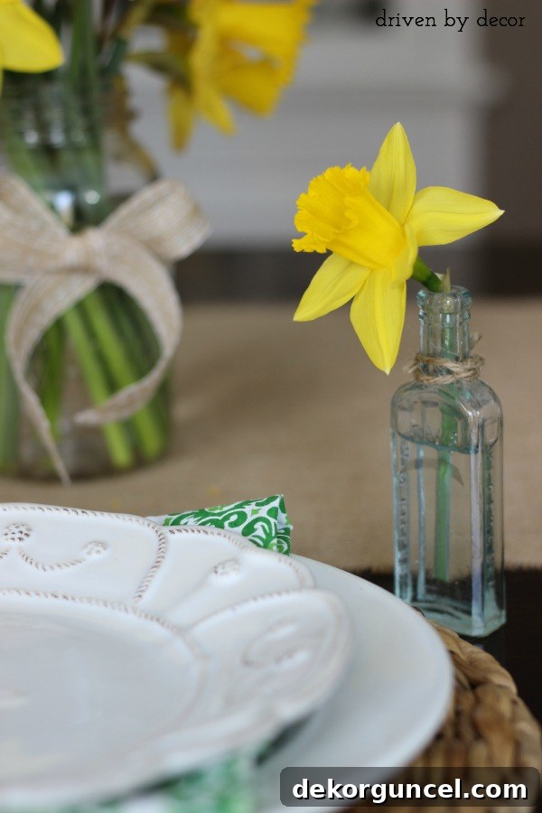 A single cut daffodil in vintage glass medicine bottle as part of simple spring tablescape