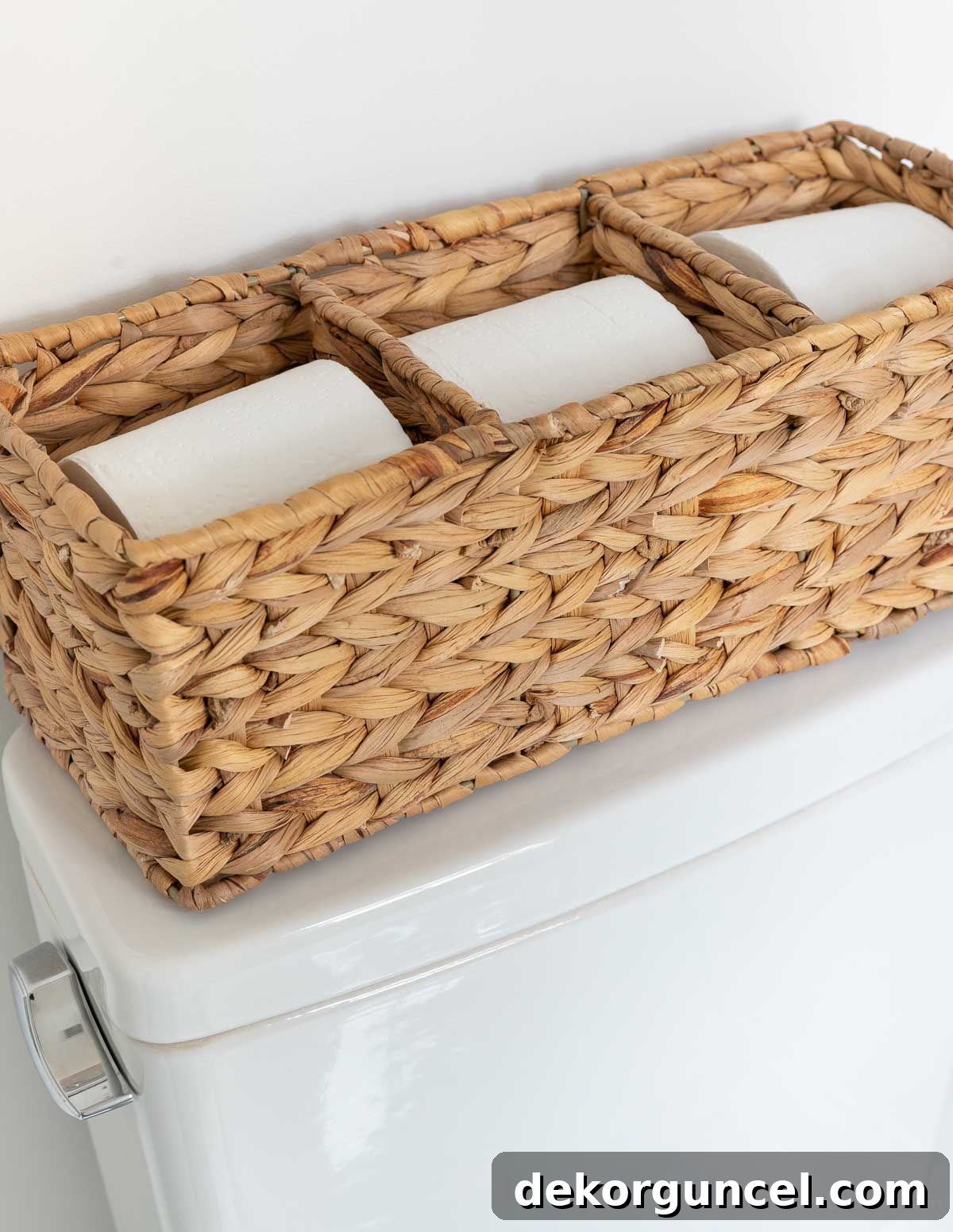 10 Smart Buys for Affordable Home Style 17 A stylish woven toilet paper holder neatly positioned on a toilet tank, offering practical storage.