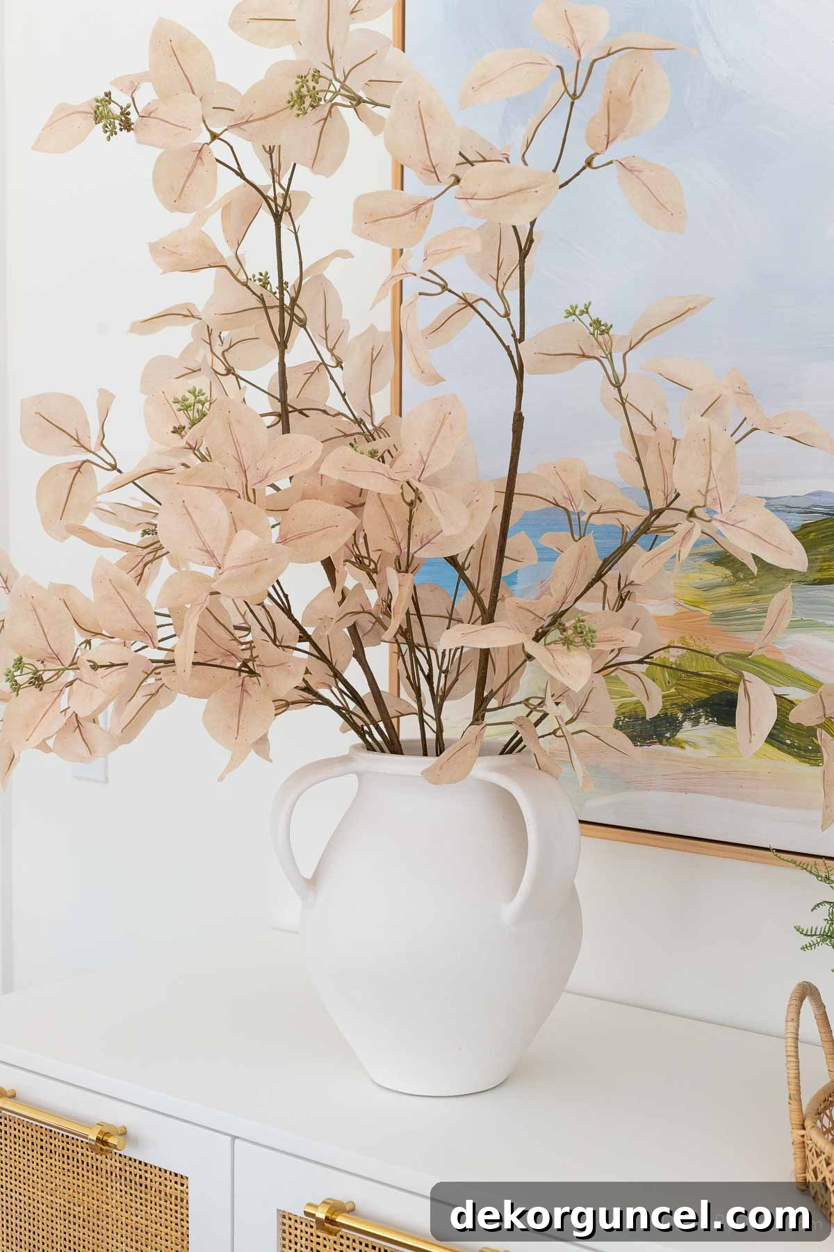 White ceramic vase with lush faux leafy branches