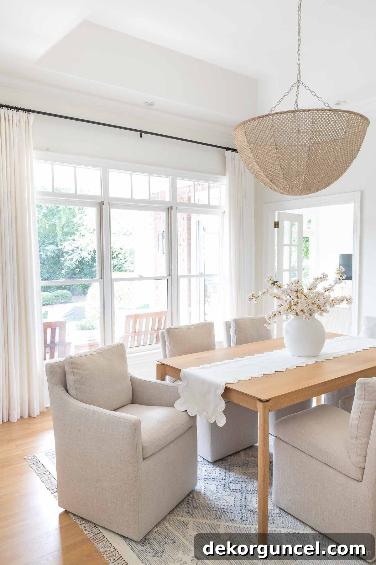 Dining room featuring flatweave blue and white rug and elegant chandelier