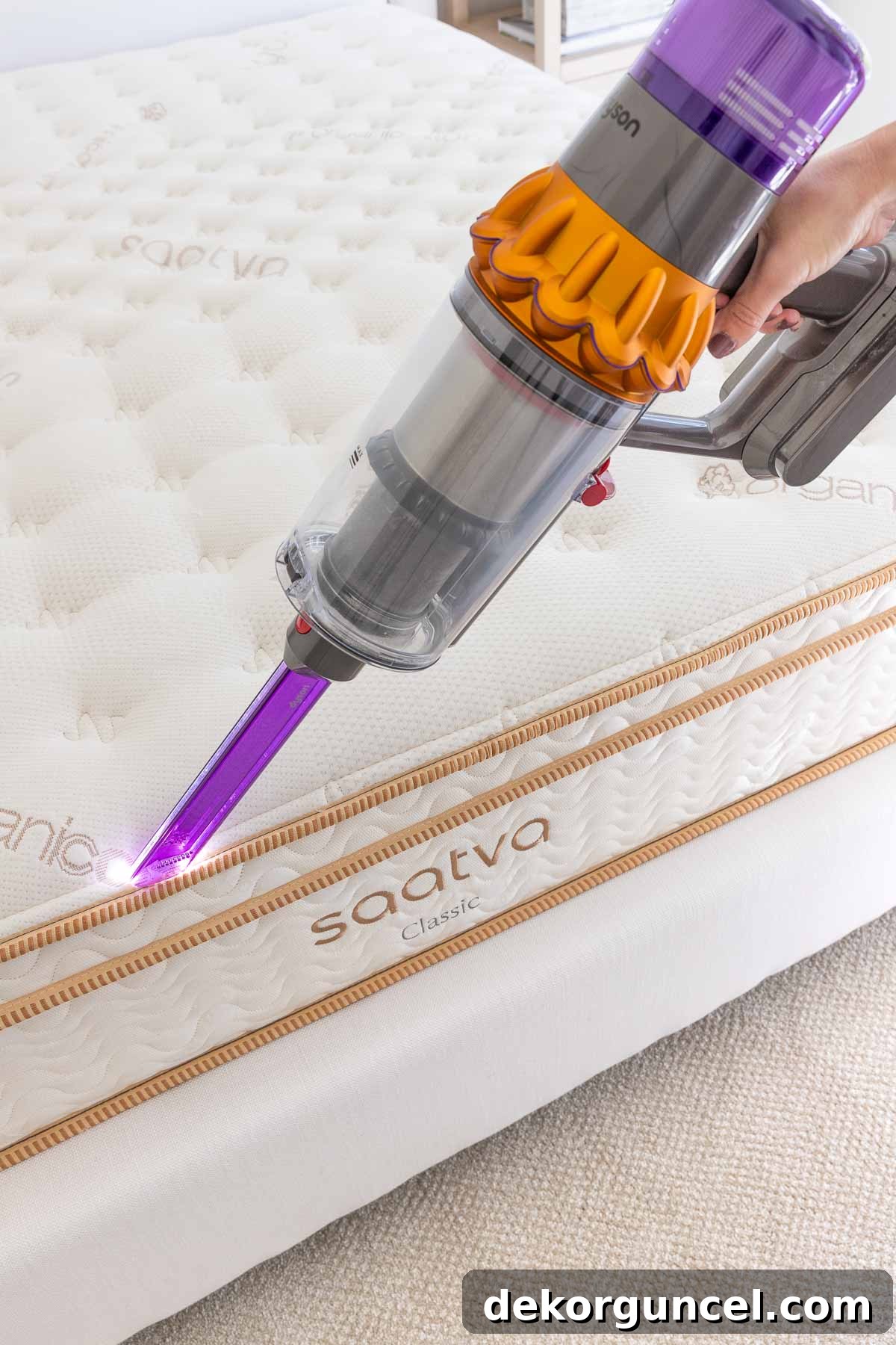 Your Complete Mattress Guide: Shopping, Cleaning, and Care 8 Vacuuming edges of mattress with the crevice tool on a handheld vac