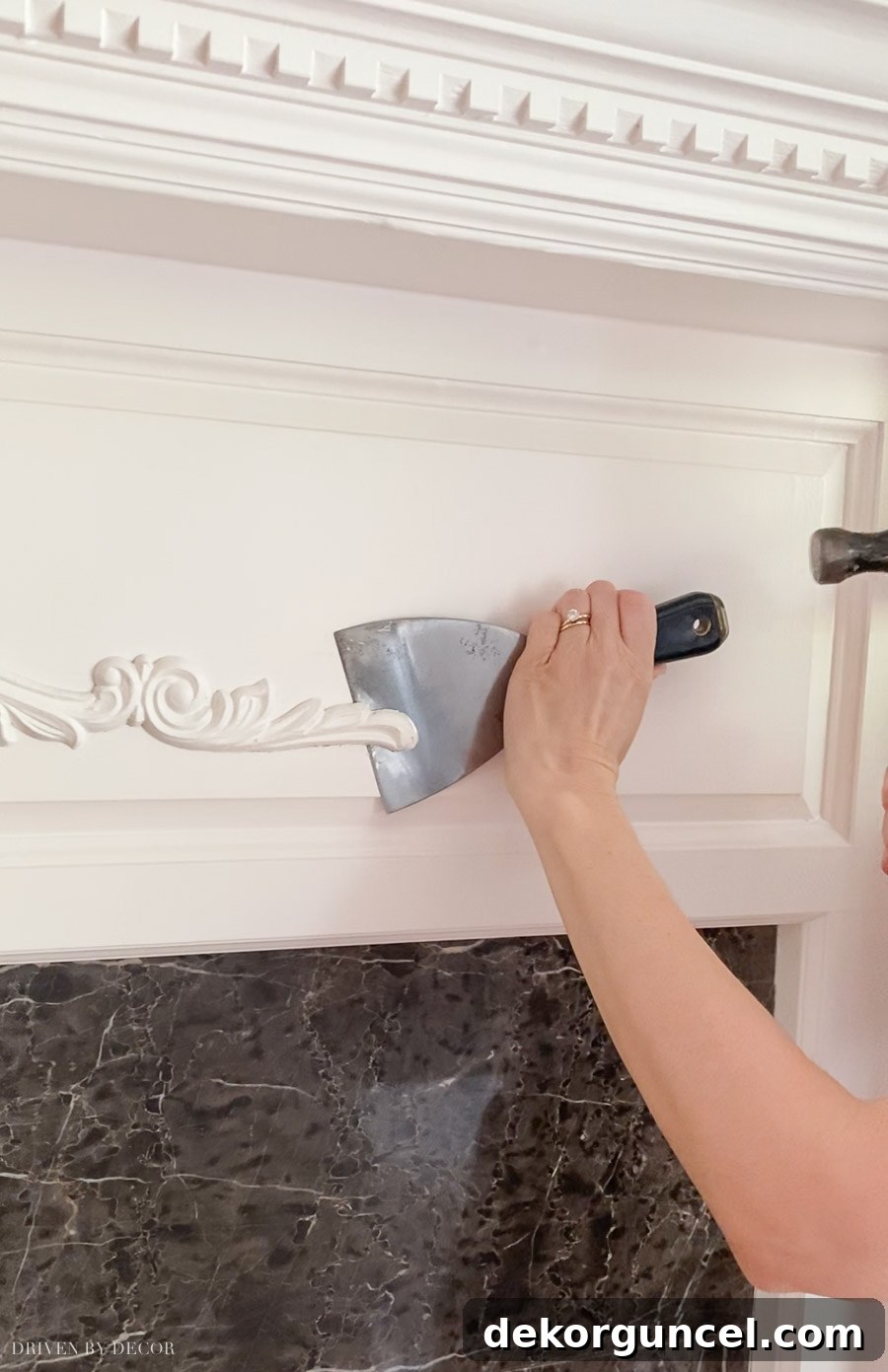 Spray Paint Your Brass Fireplace for an Instant Update 5 Process of carefully removing the dated fireplace applique using a putty knife and hammer.