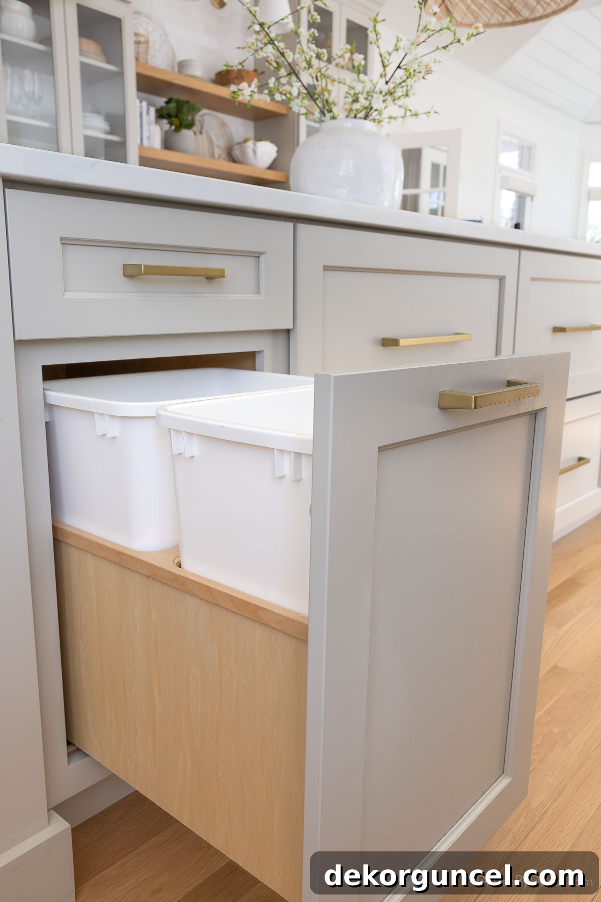 Double trash can pull-out integrated seamlessly into the kitchen island