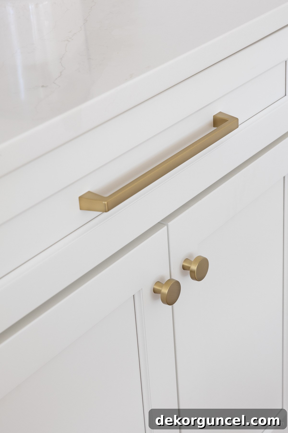 Gold pulls and mushroom knobs elegantly adorning white kitchen cabinets, adding a touch of sophistication