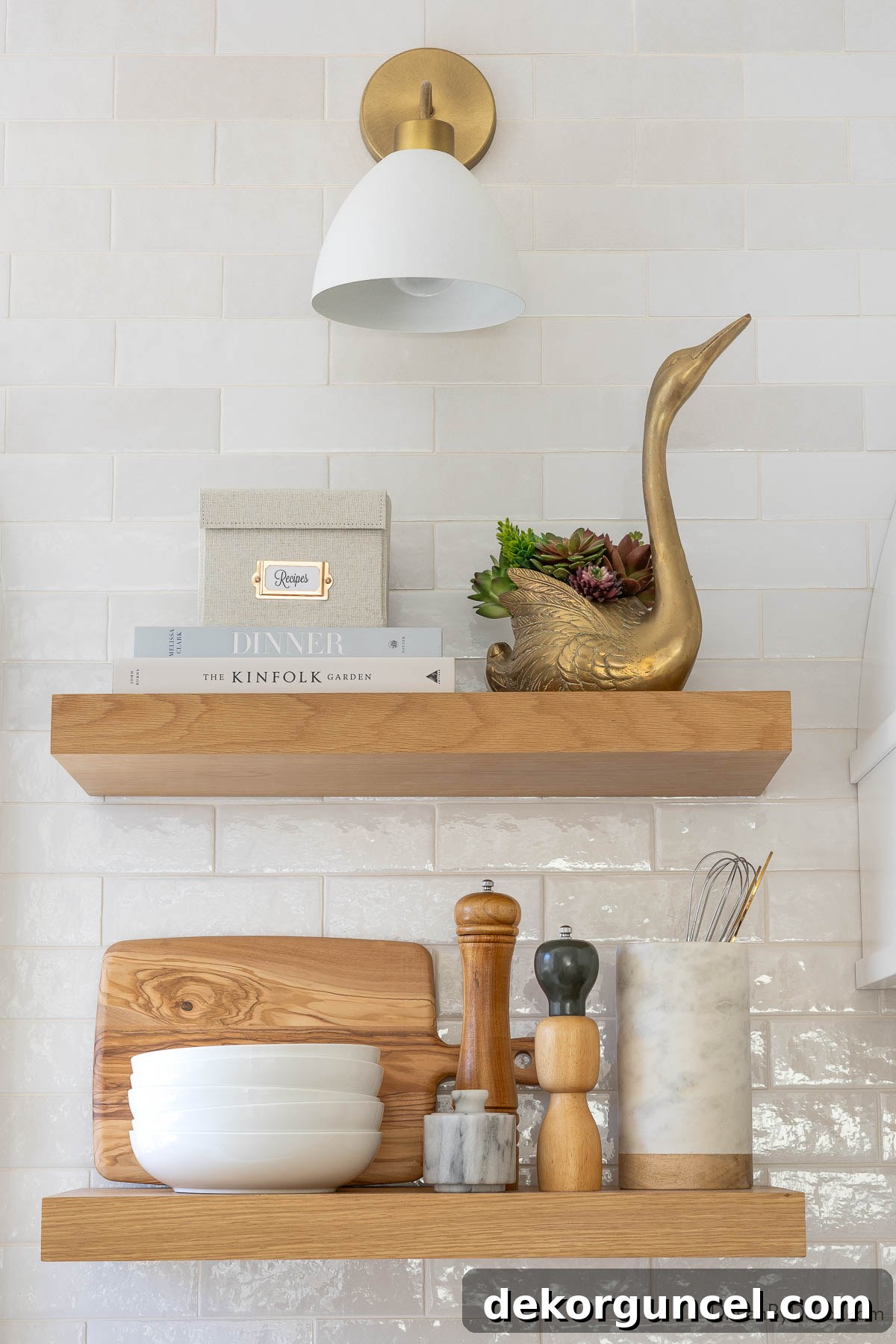 Styled floating white oak shelves in the kitchen, featuring a recipe box, pasta bowls, and cooking utensils