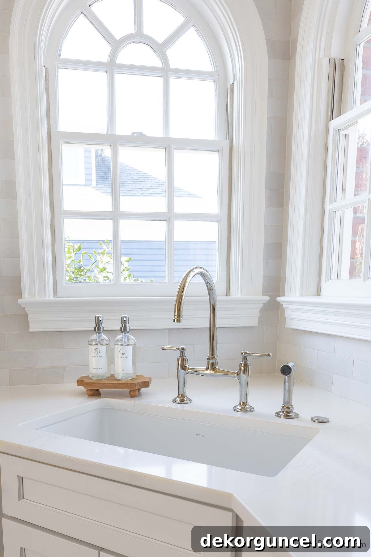 Elegant corner sink in our kitchen, featuring a polished nickel bridge faucet beneath arched windows