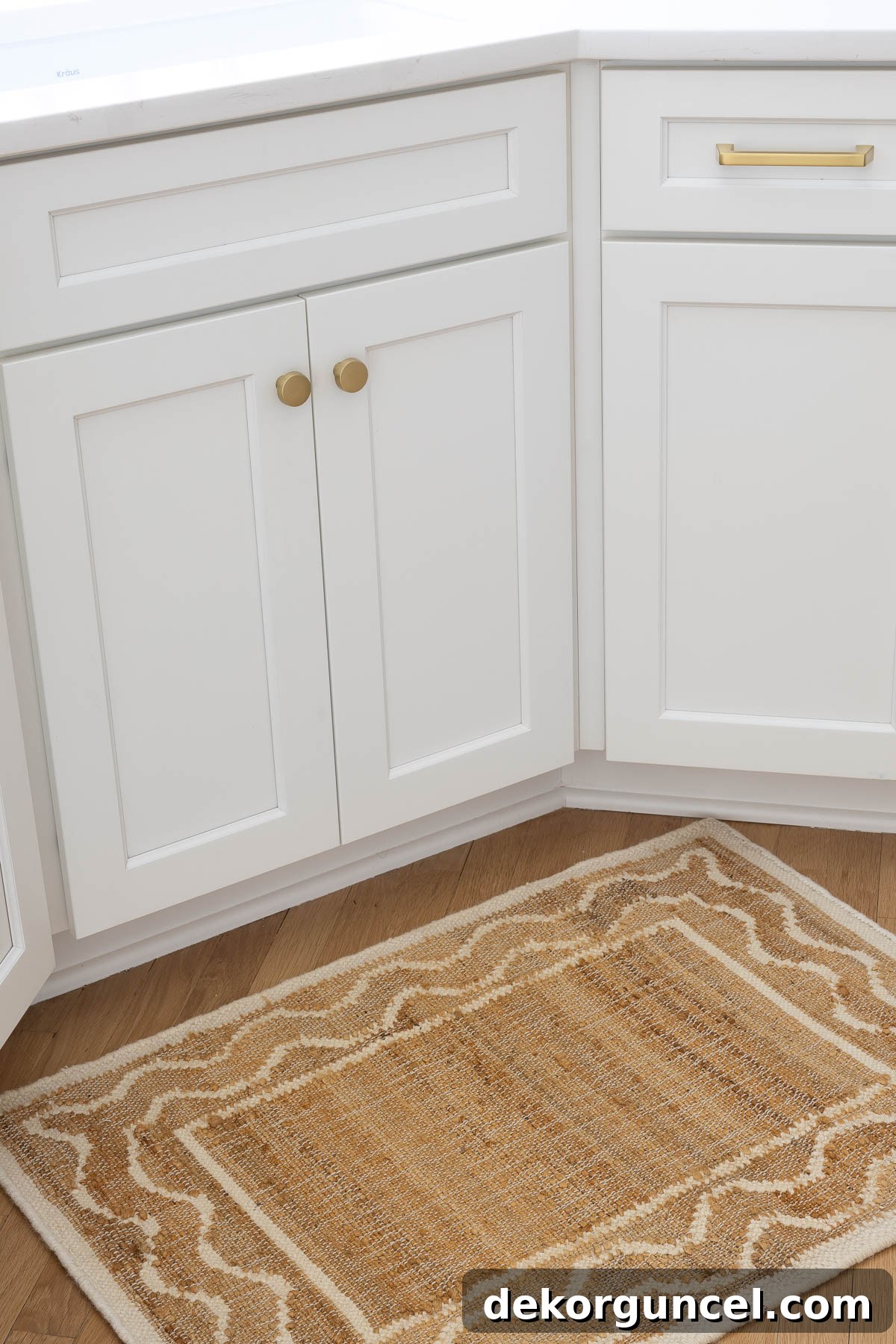 Textured woven rug positioned in front of the kitchen sink, adding warmth and style