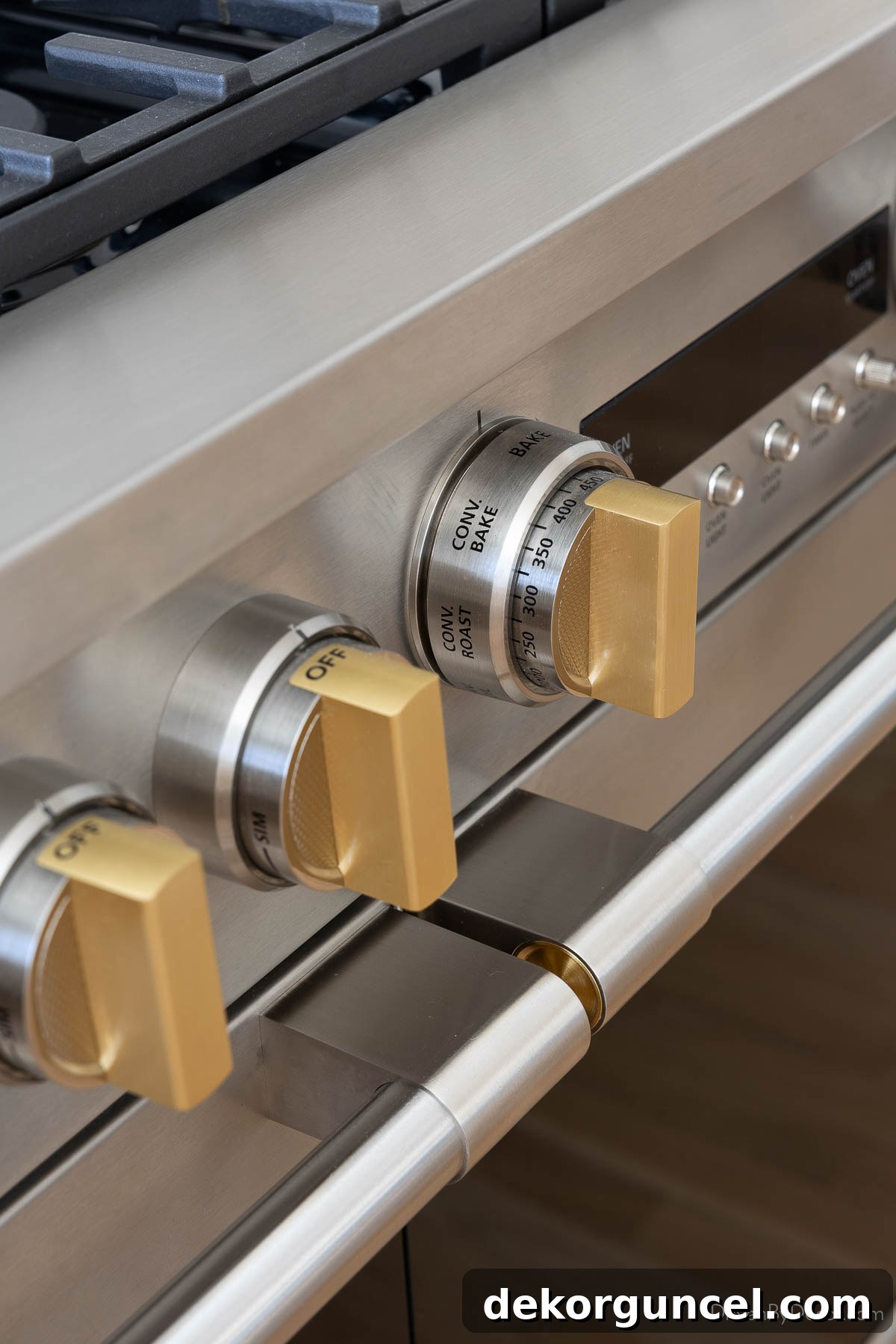Close-up of the elegant brass knobs on the Monogram range, highlighting the mixed-metal aesthetic