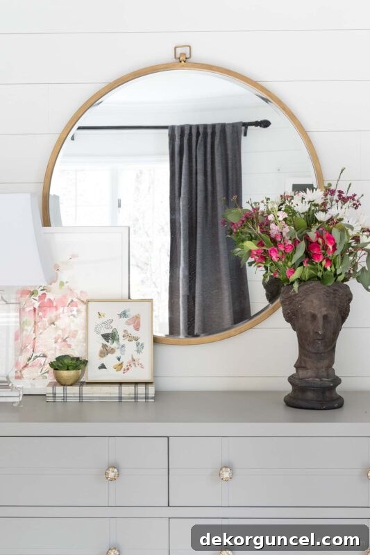 Large round mirror with pocket watch detail over dresser