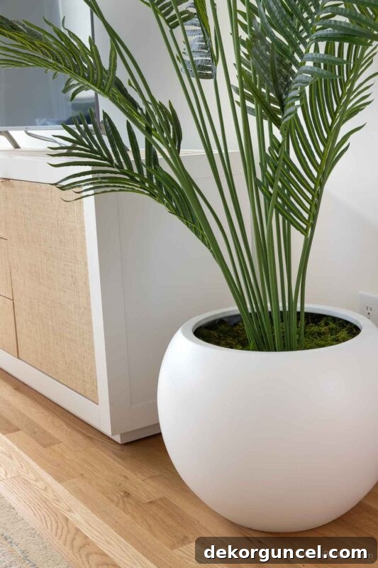 Large round white sphere planter with a faux palm tree inside
