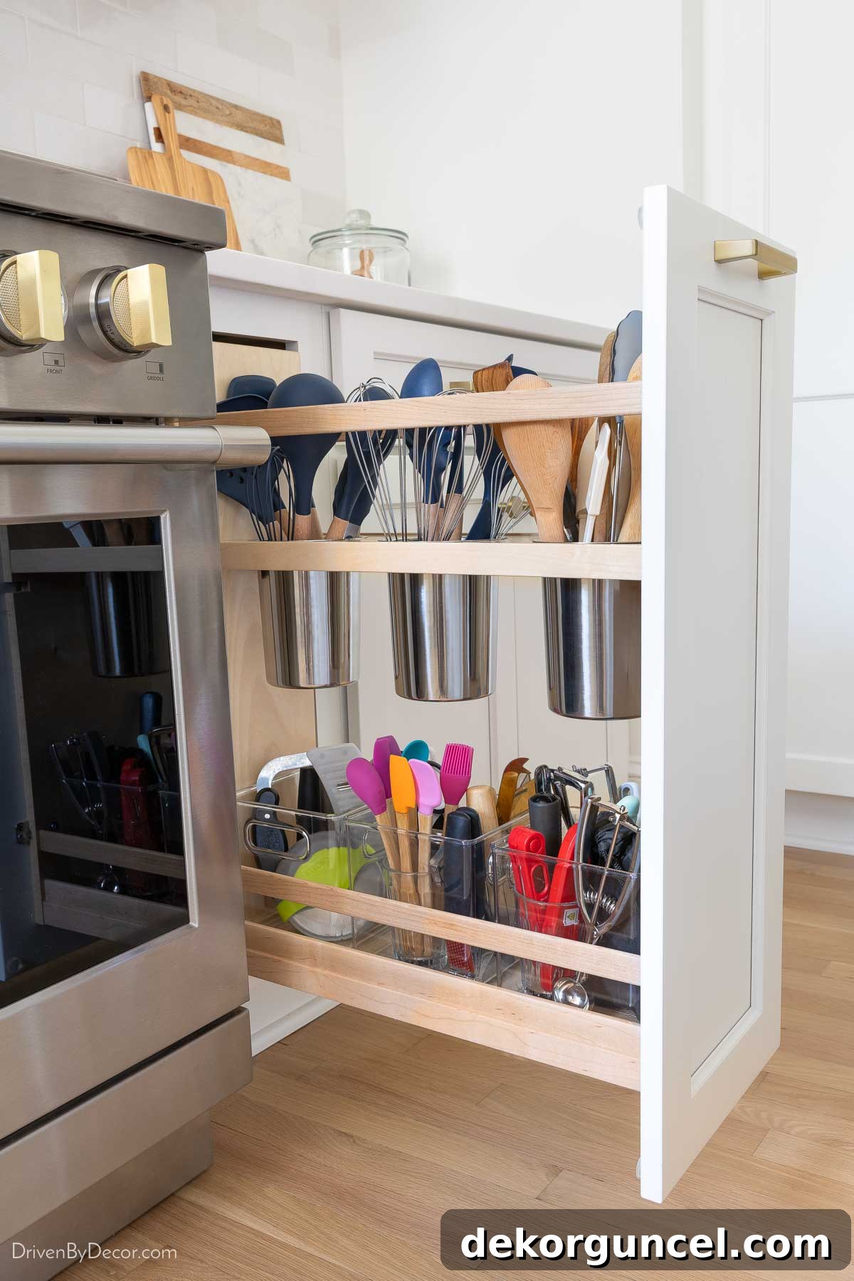 Built-in kitchen utensil pull-out cabinet storing cooking tools vertically near the stove.