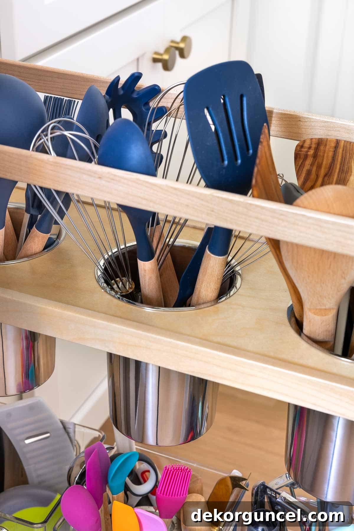 Interior view of a kitchen pull-out showing various utensils neatly organized in dedicated compartments.
