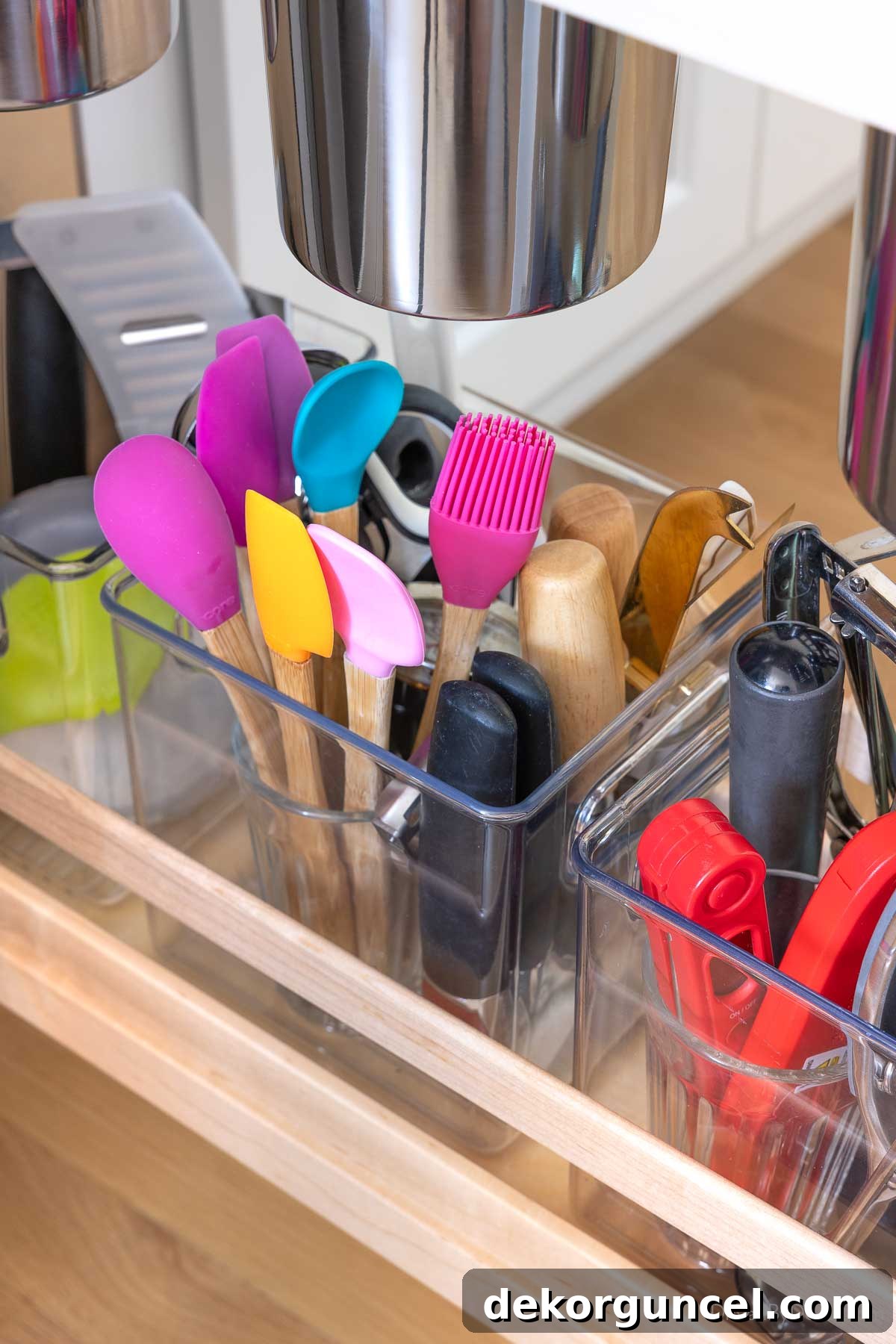 Clear organizer bins on the bottom shelf of a kitchen pull-out for small utensils and gadgets.