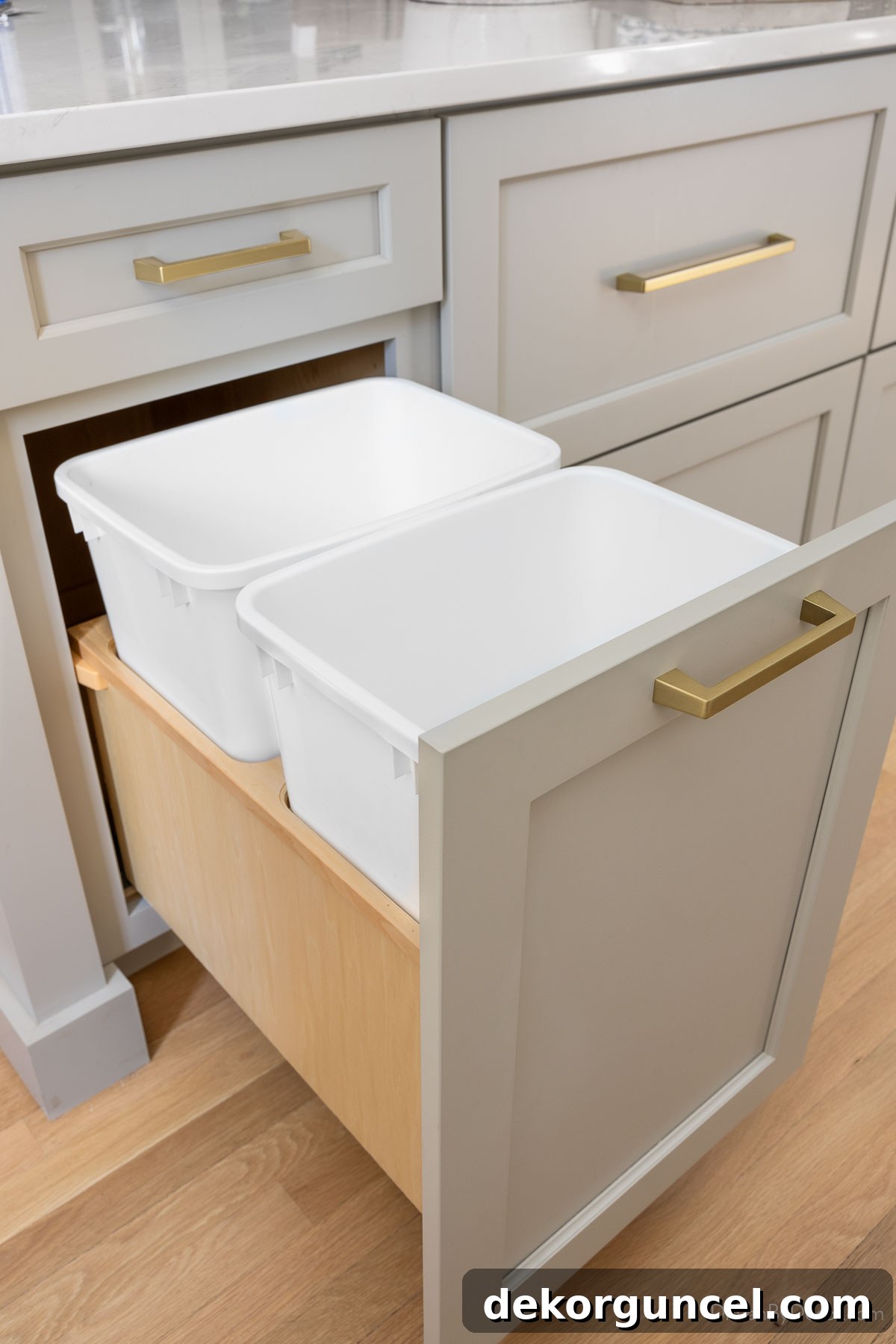 Built-in double trash can pull-out in a modern kitchen cabinet for trash and recycling.