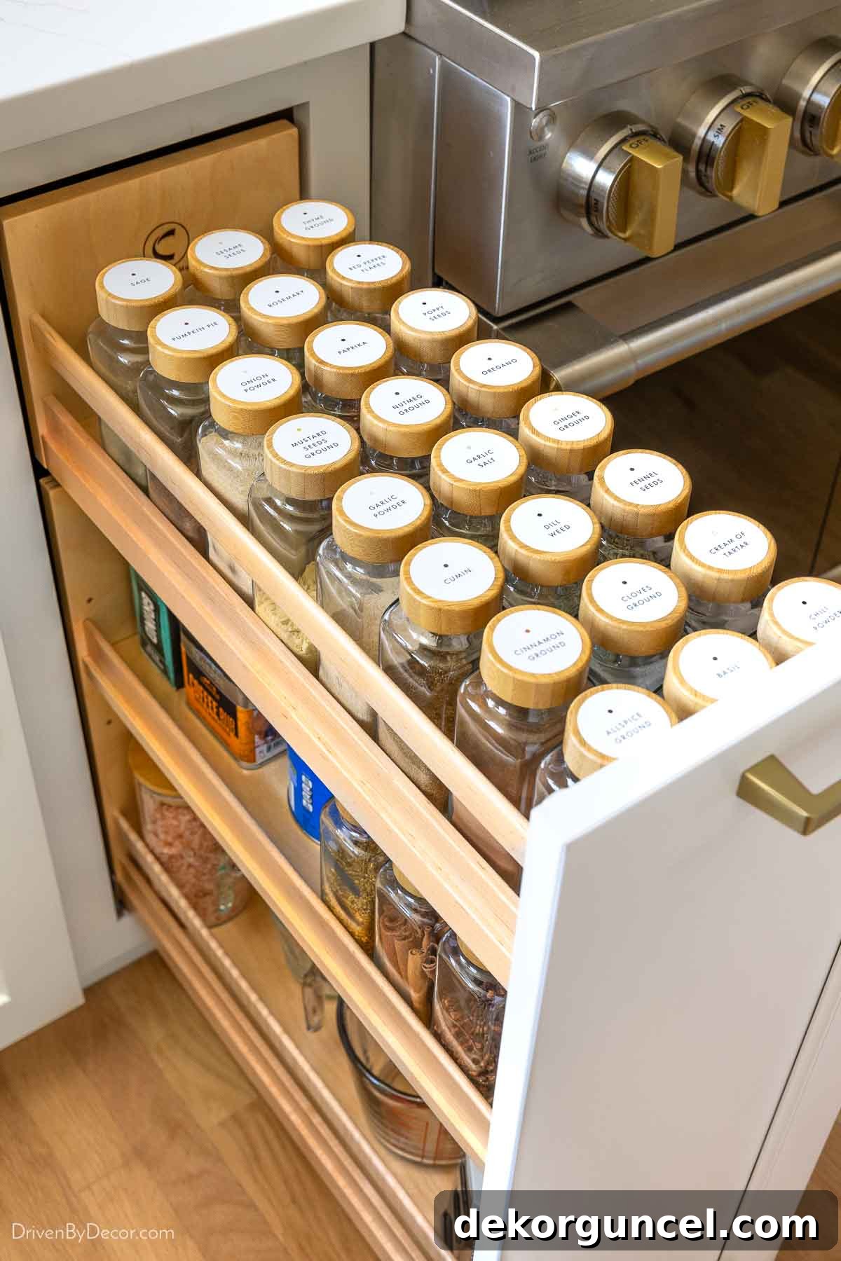 Close-up of neatly organized and labeled spice jars within a kitchen pull-out cabinet.
