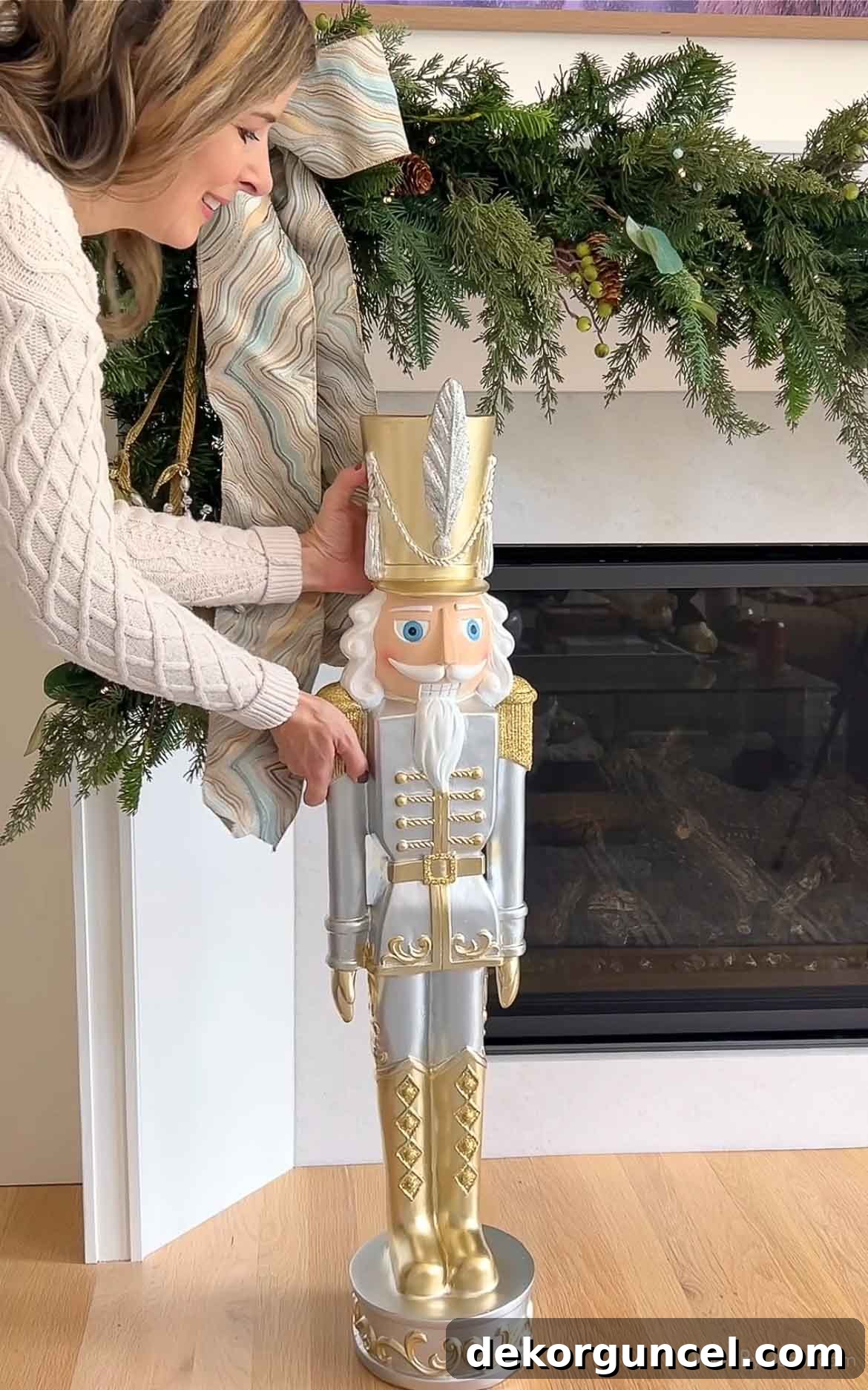 Gold and silver nutcracker standing proudly next to a decorated fireplace