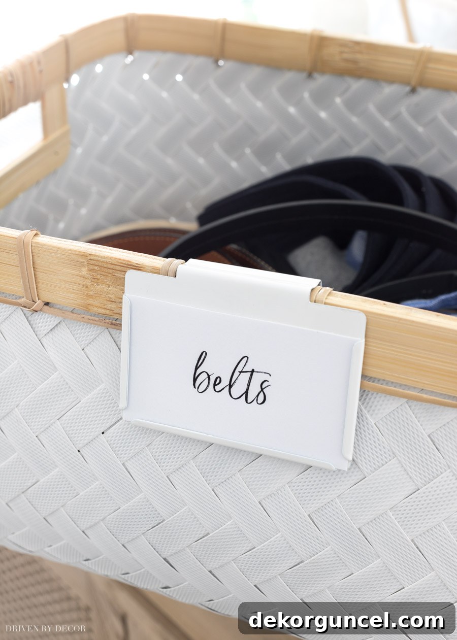 Close-up of stylish white woven storage bins with labels attached by bin clips, neatly organized in an IKEA PAX closet.