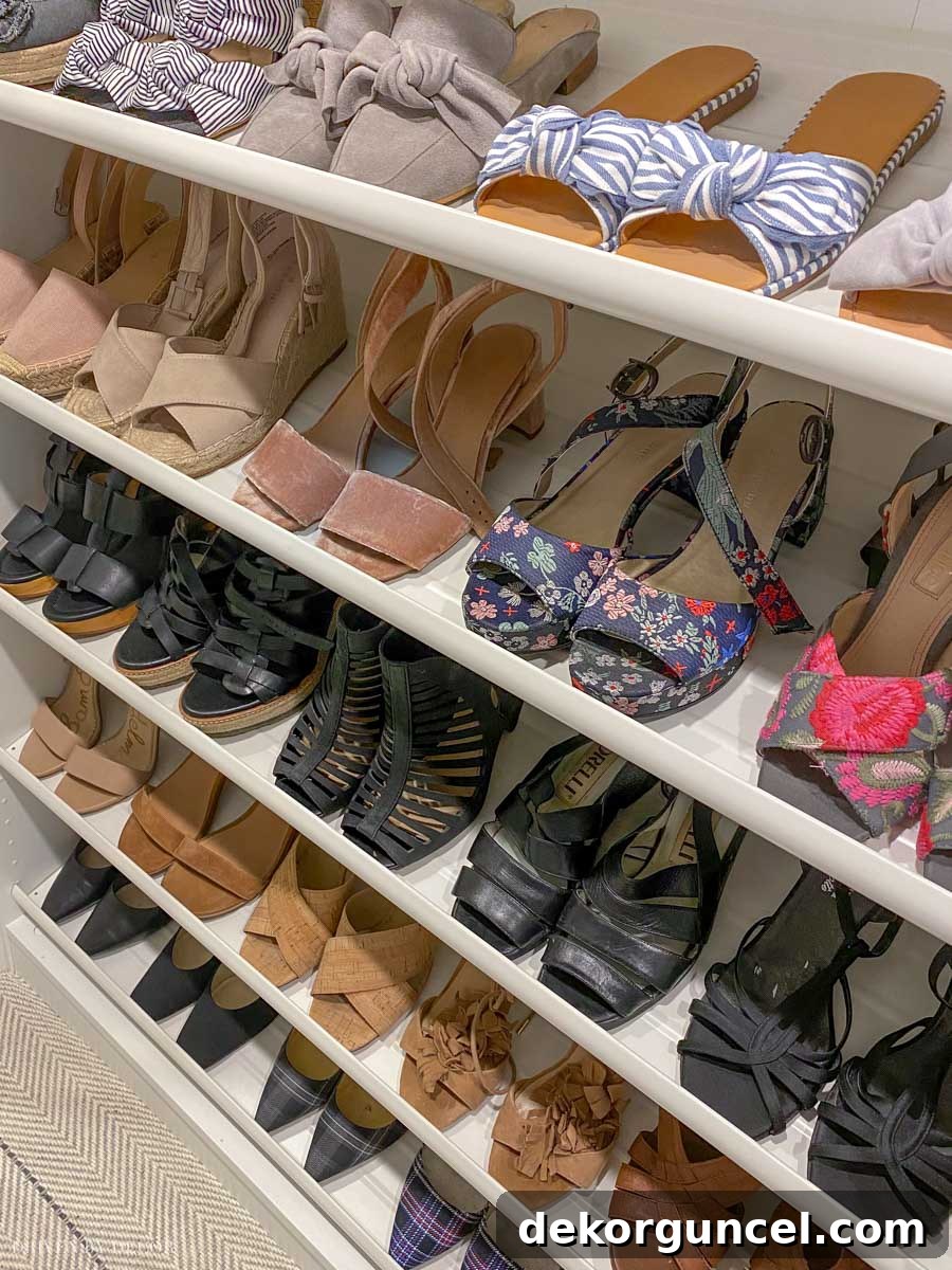 An array of shoes neatly displayed on IKEA KOMPLEMENT shoe shelves within a PAX wardrobe, showcasing efficient and accessible storage.