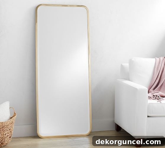 A stunning full-length brass floor mirror positioned at the end of a walk-in closet, adding both style and functionality.