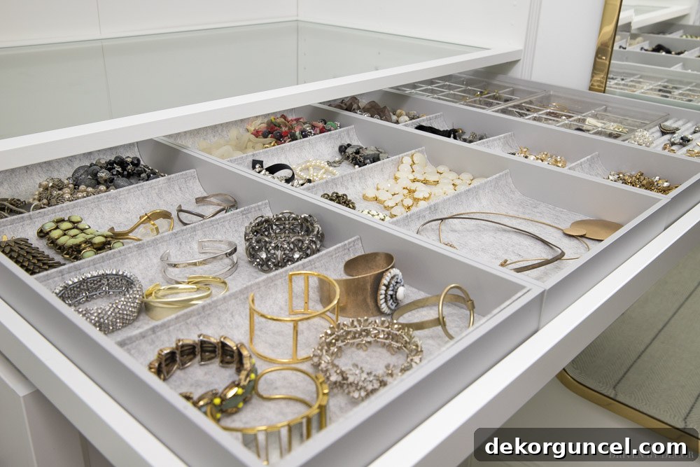 A stunning IKEA KOMPLEMENT pull-out tray, meticulously organized with inserts for a vast jewelry collection in a PAX closet system.
