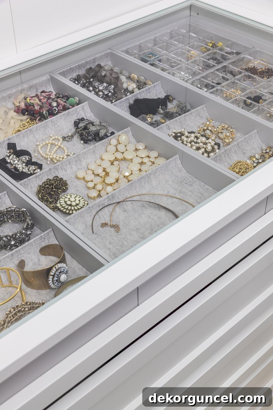 A transparent glass shelf installed above a pull-out jewelry tray in an IKEA PAX closet, providing clear visibility of all contents.